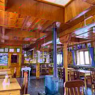 Intérieur en bois d'une tea house lodge traditionnelle lors d'un trek au Népal.