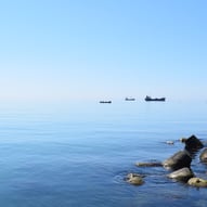Steinküste mit Booten auf dem Meer