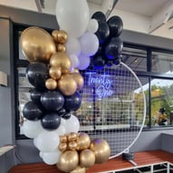 Circle backdrop with reflex gold, black and white garland for 21st at Victoria Point.