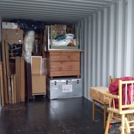 Conteneur de stockage rempli de meubles en bois, cartons de déménagement, objets emballés et mobilier divers, parfaitement or