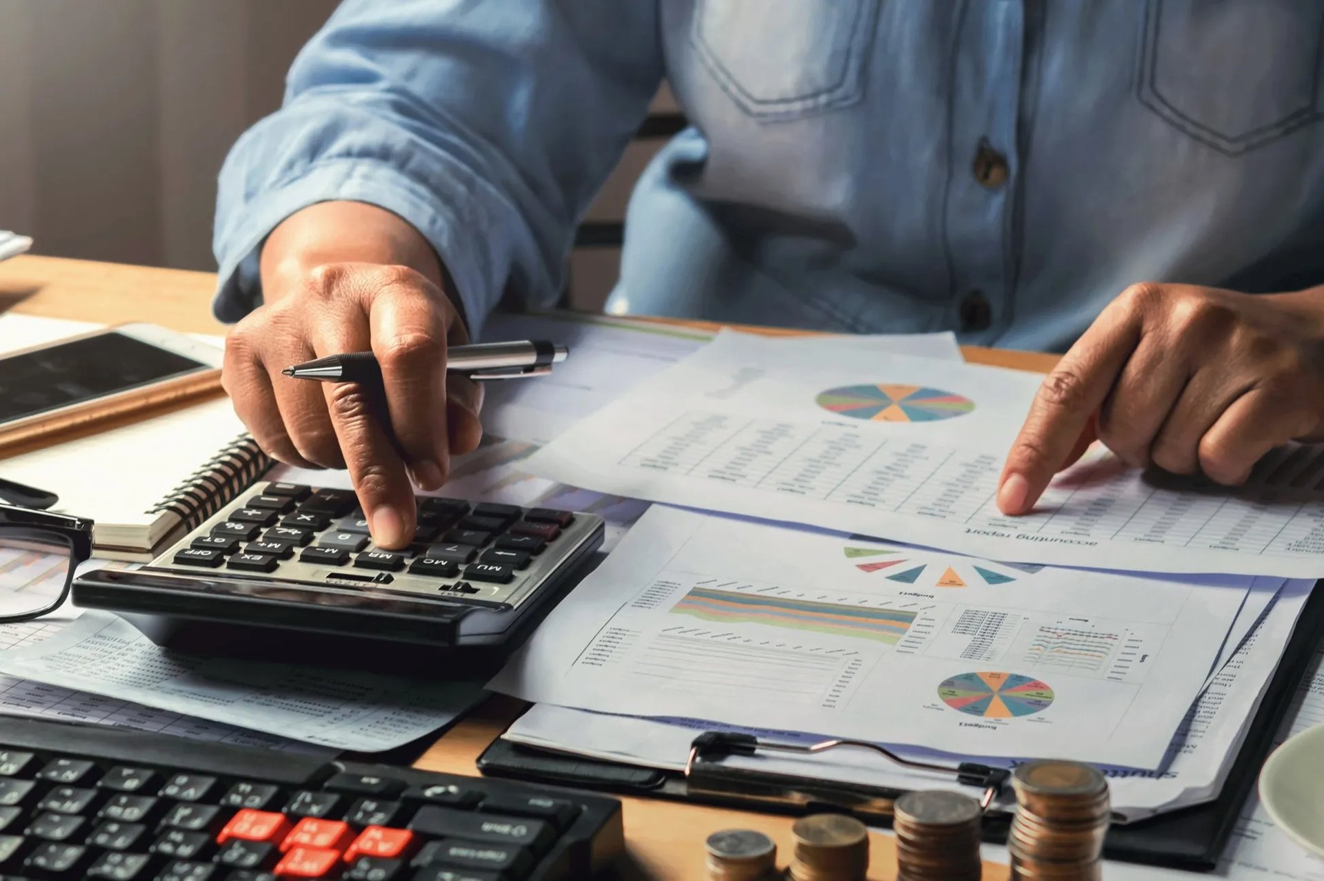 Especialista da Consultoria Brandão realizando análise técnica de relatórios financeiros e gestão de custos com calculadora