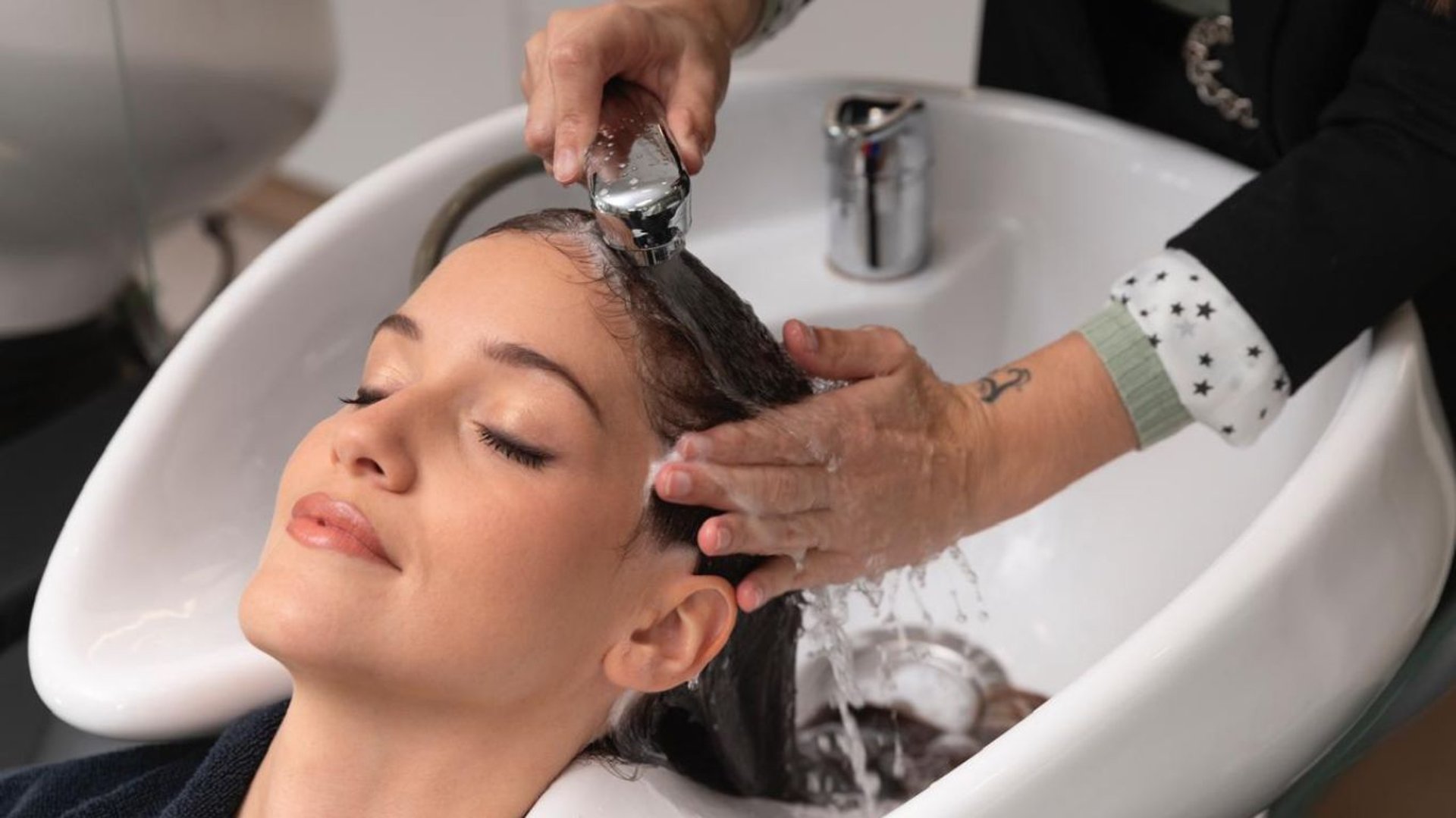 a woman getting her hair washed with a hair dryer