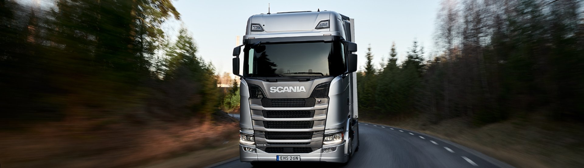 Two scania trucks parked outside a building