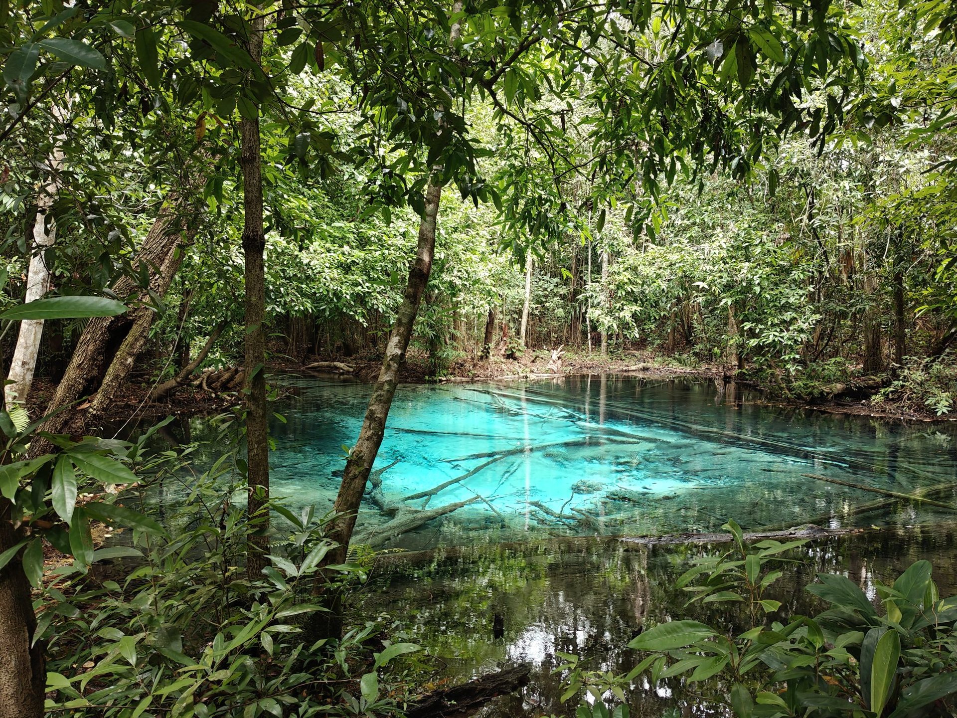 A sandy beach with a rock formation in the background