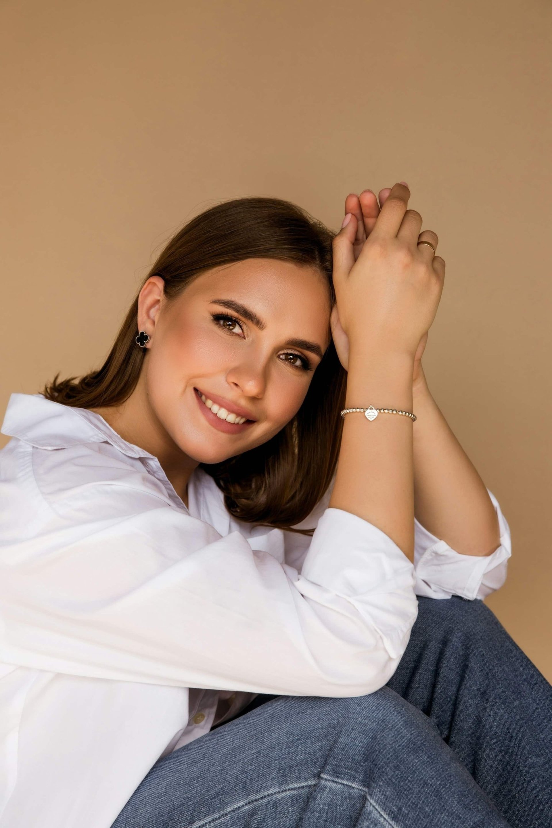 woman wearing white top and wearing gold-colored bracelets