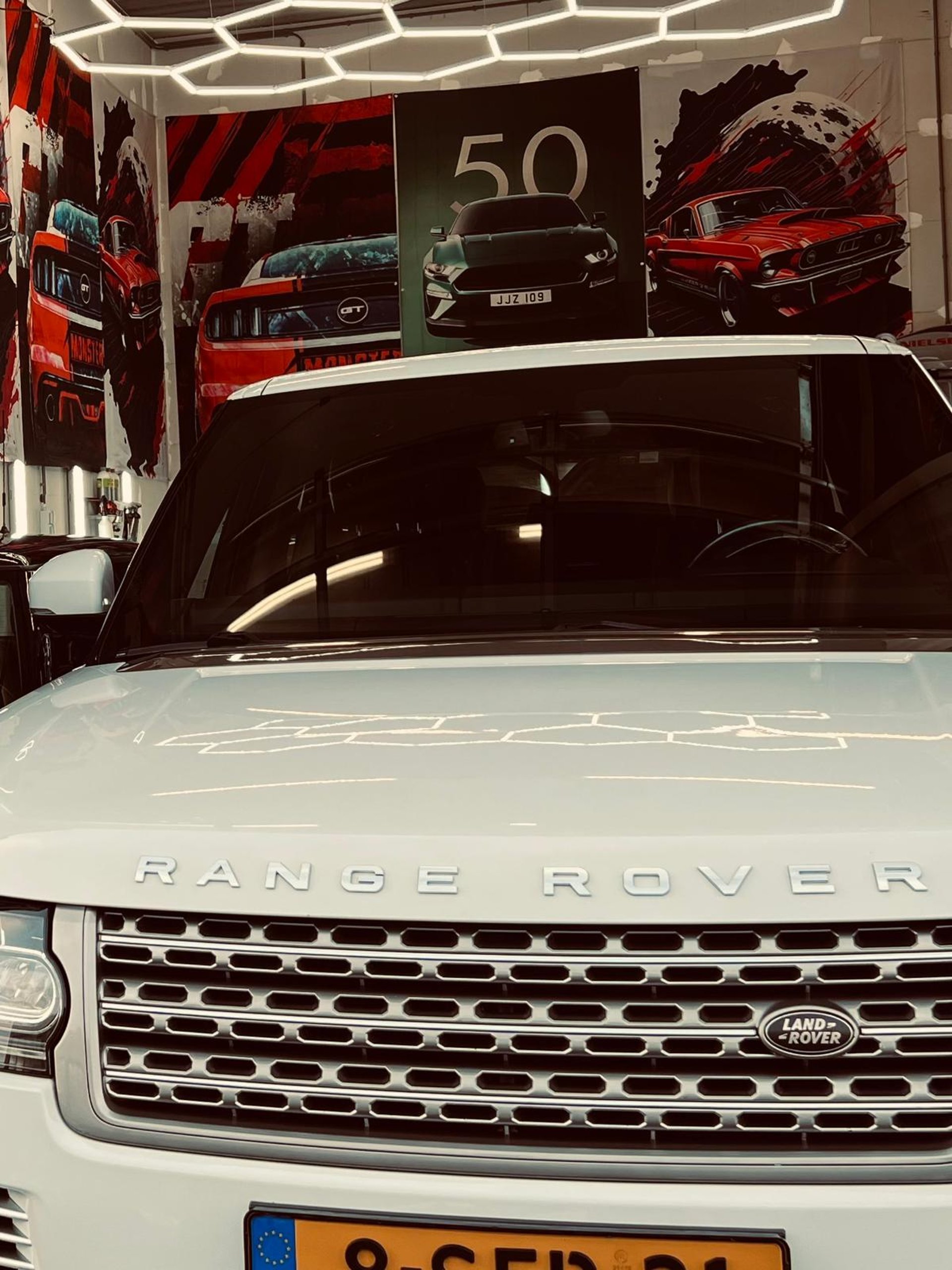 white Aston Martin convertible parked near trees