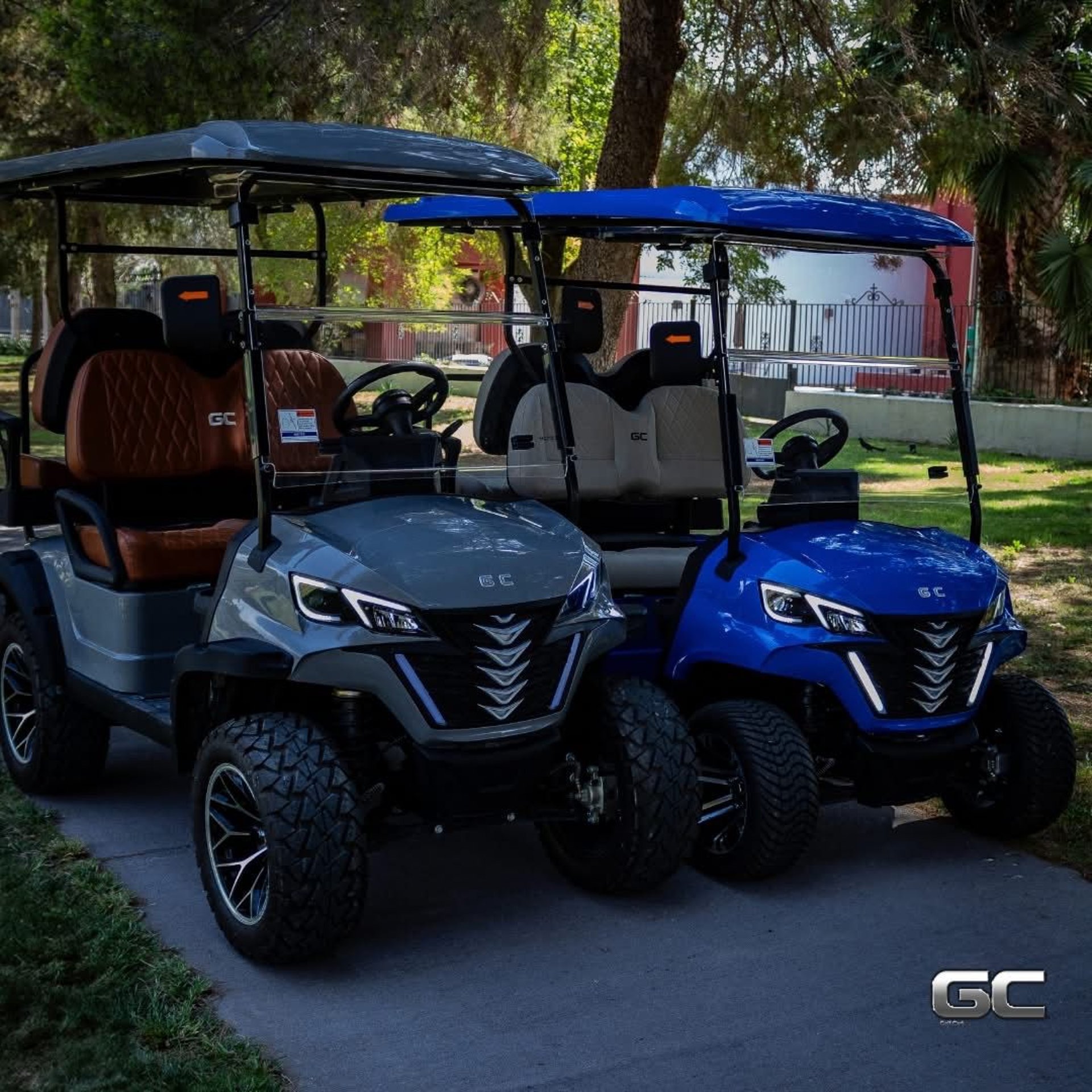 man in white t-shirt and black pants standing on golf cart on green grass field