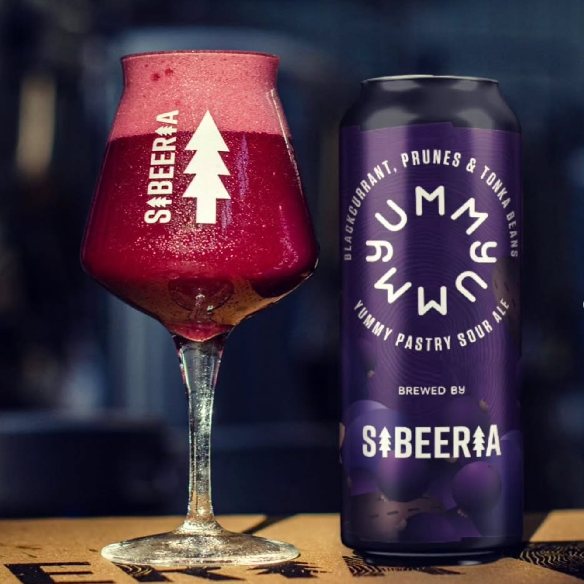 a glass of beer sitting on top of a wooden table