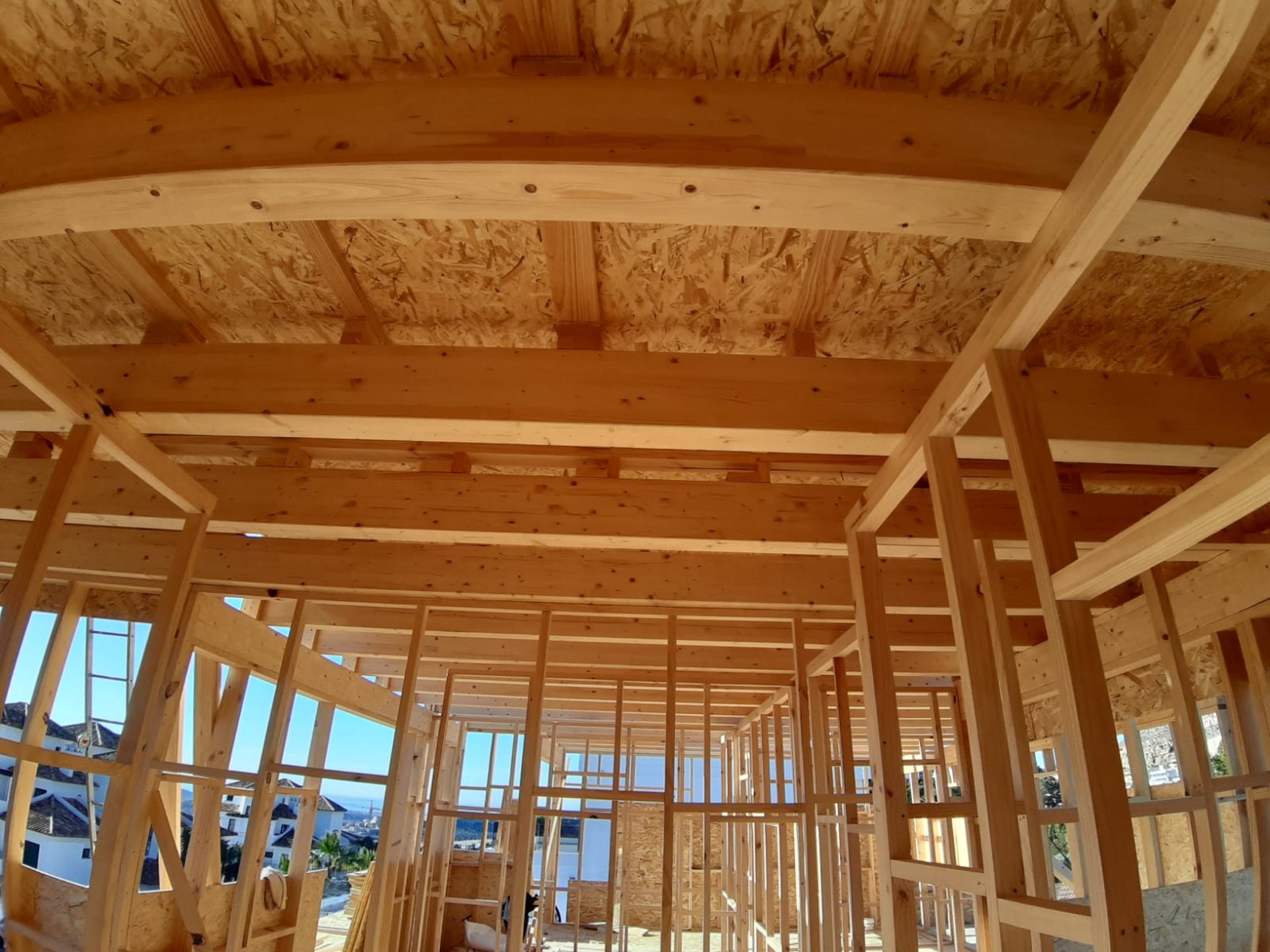 an abstract photo of a curved building with a blue sky in the background