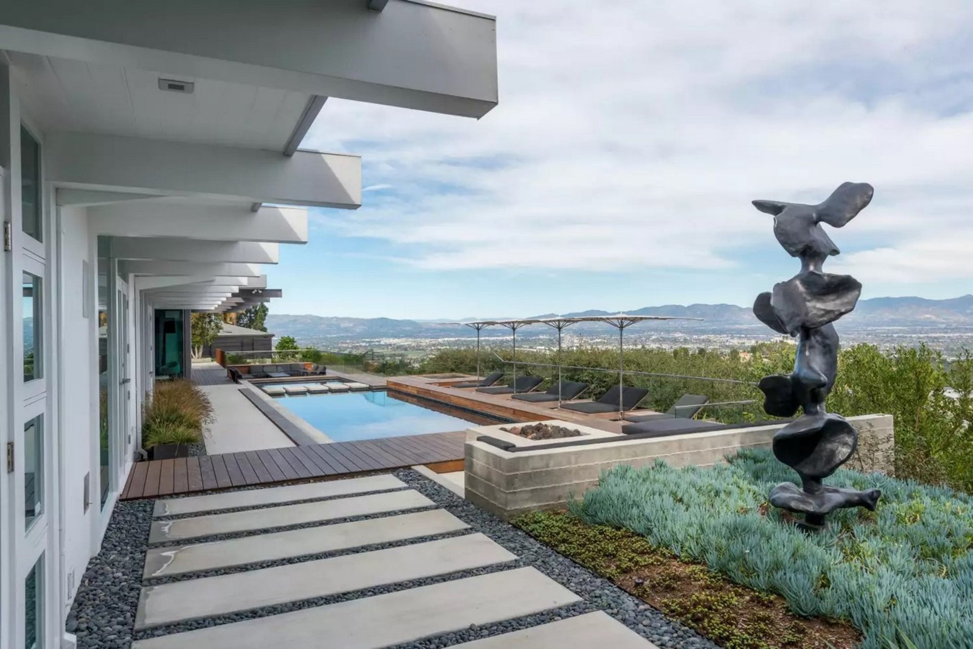a backyard with a pool and a house in the background
