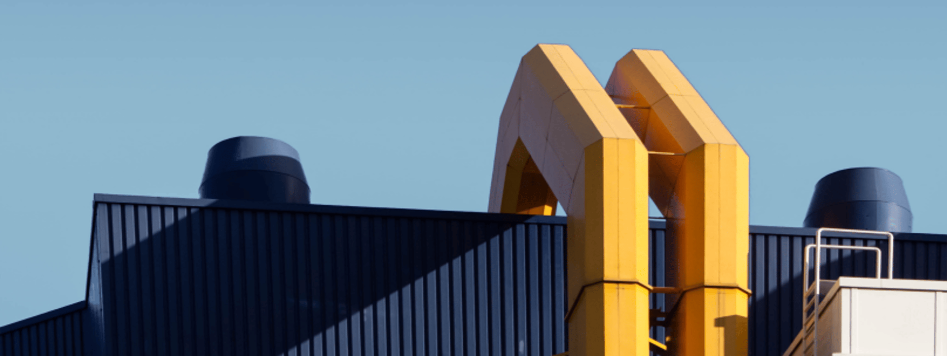 an abstract photo of a curved building with a blue sky in the background