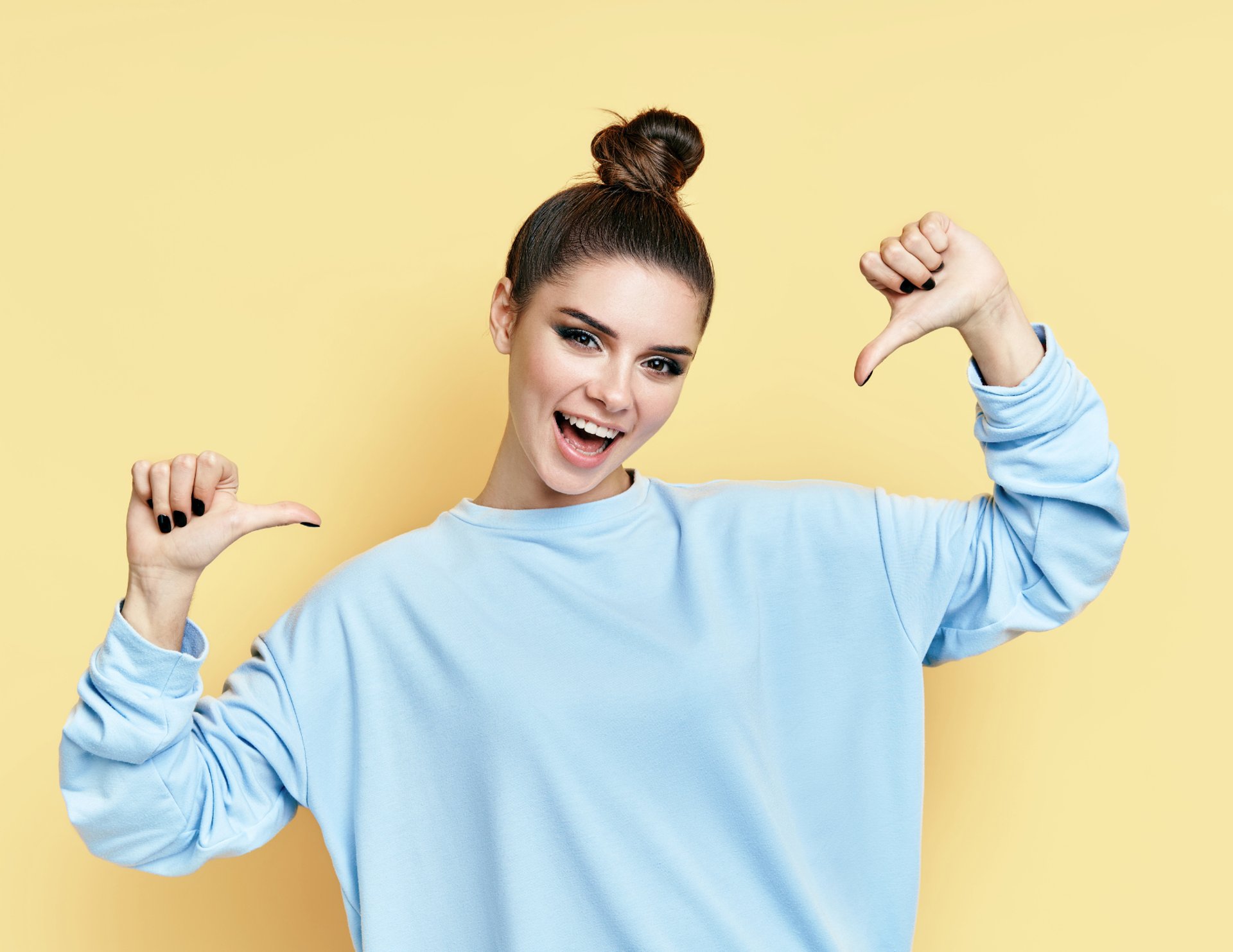 happy, up-beat with a girl pointig at herself wearing a blue shirt and yellow background