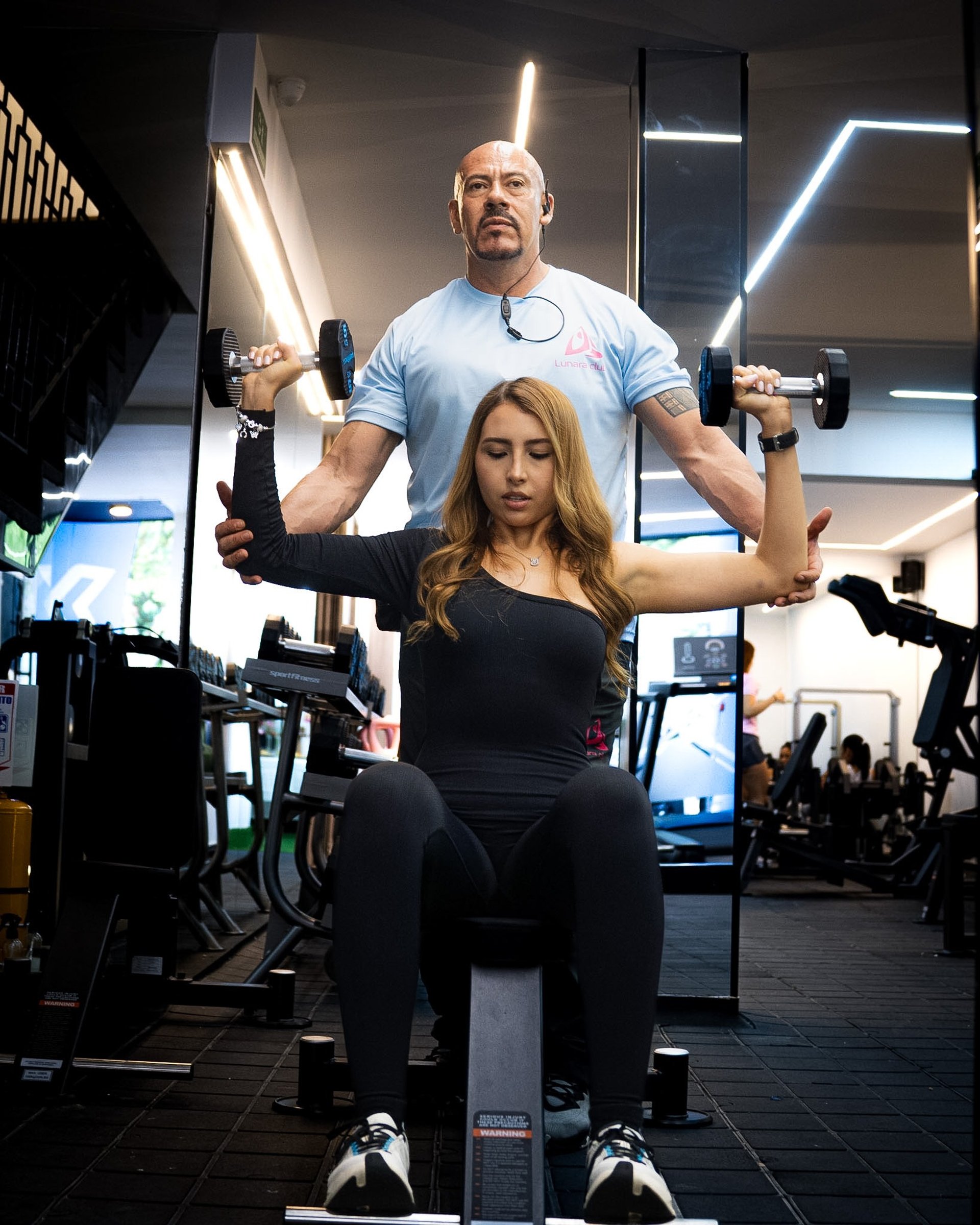 person locking gym plates on barbell
