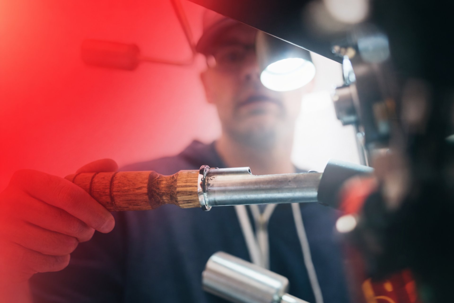 man wearing black pullover hoodie holding tool