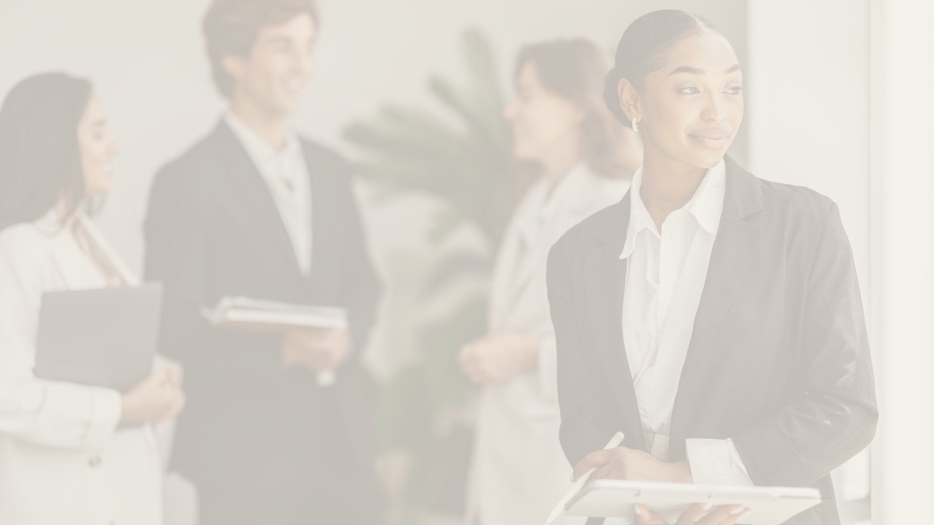 Professional businesswoman smiling during a meeting, taking notes at an office table with a laptop in the background.