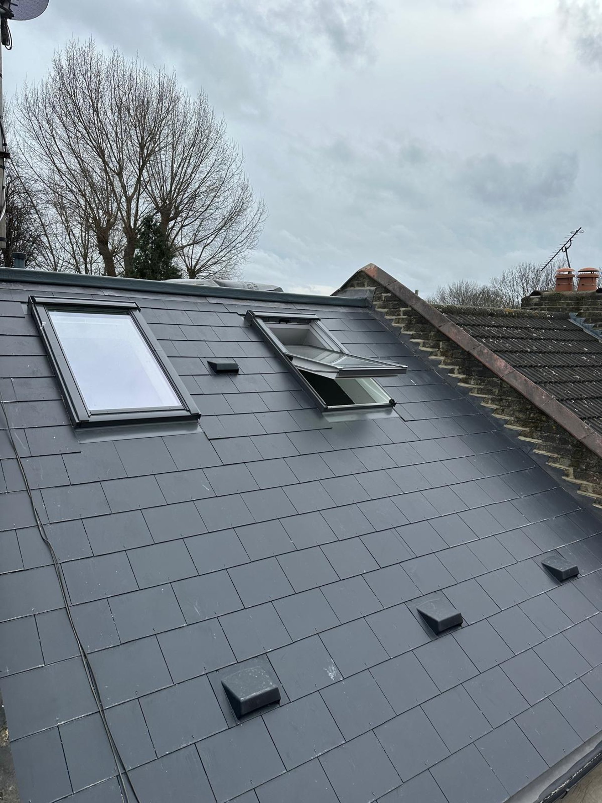 person in blue long sleeve shirt sitting beside black laptop computer