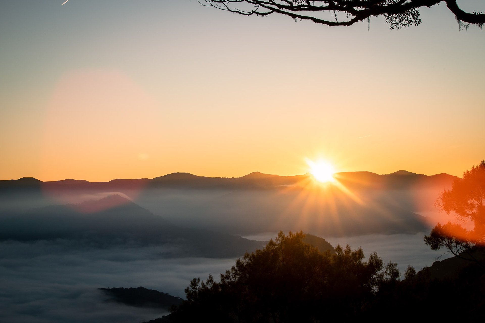 Vista panoramica para as montanhas com mar de nuvens e sol nascendo no horizonte