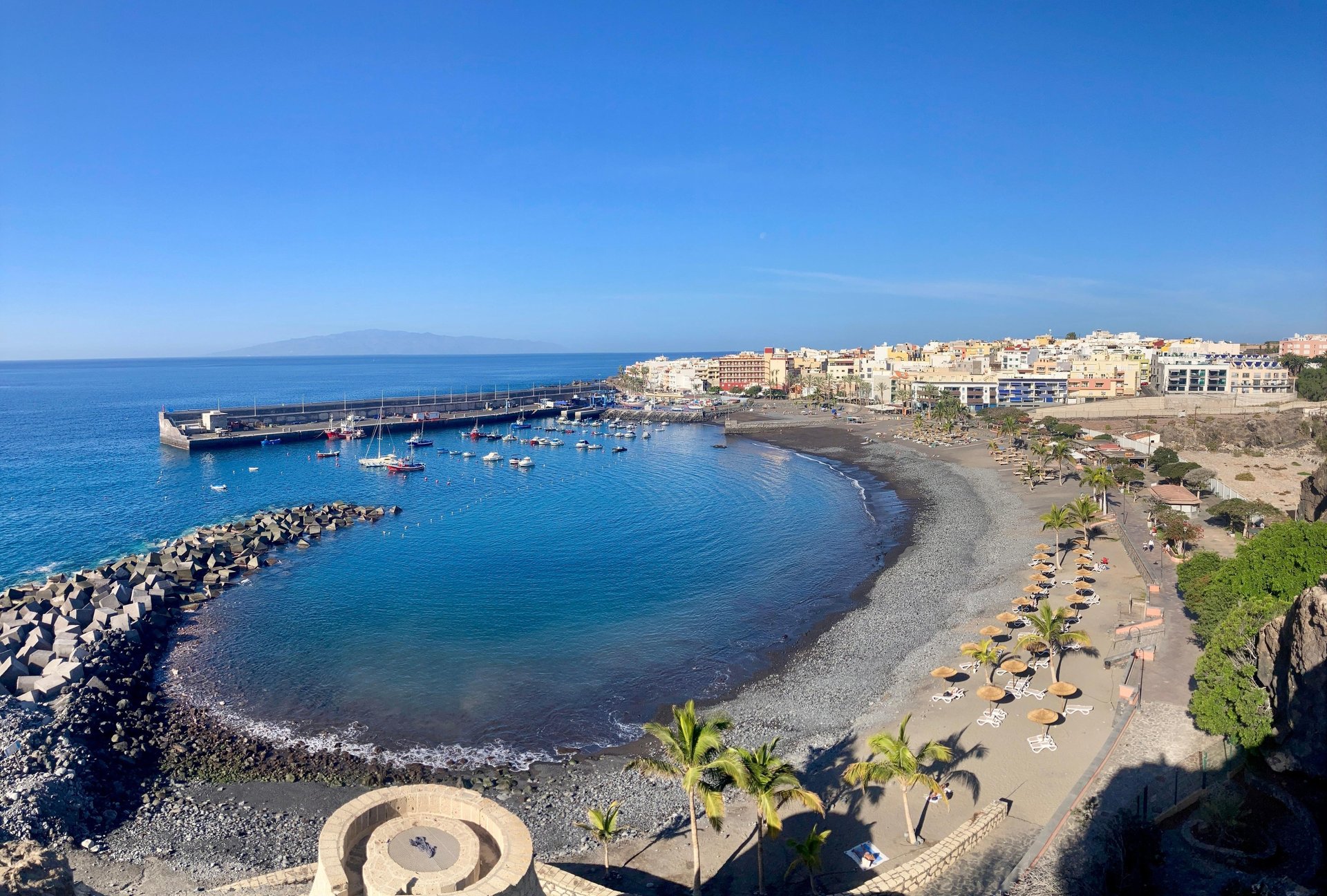 photography of mountain cliff beside seashore during daytime