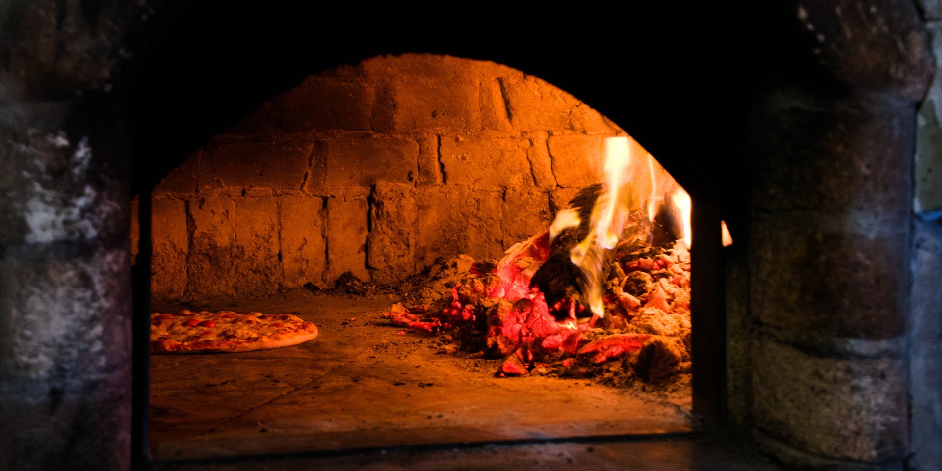 a person walking across a sandy beach next to a wave