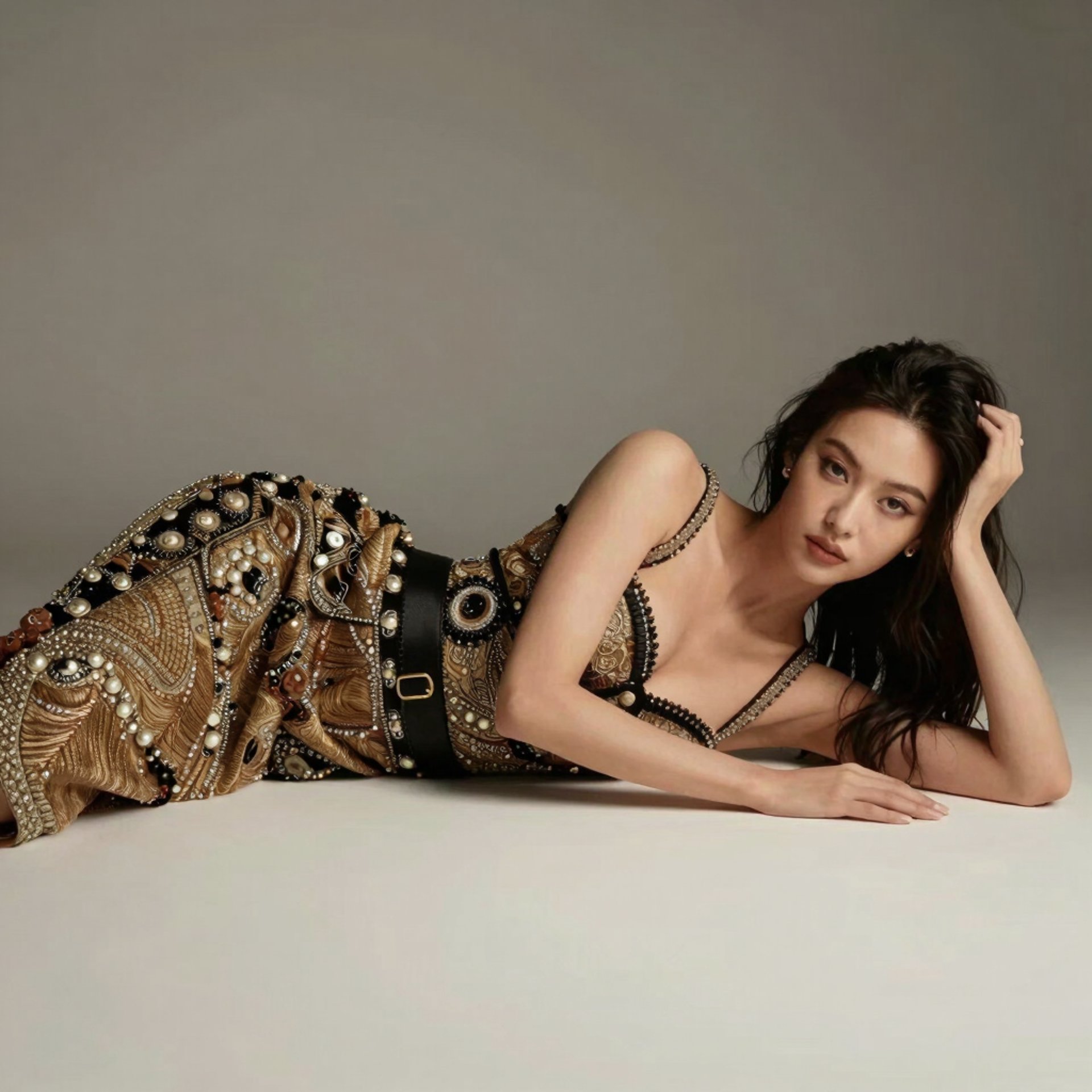 a woman in a black top and red pants sitting on a ledge