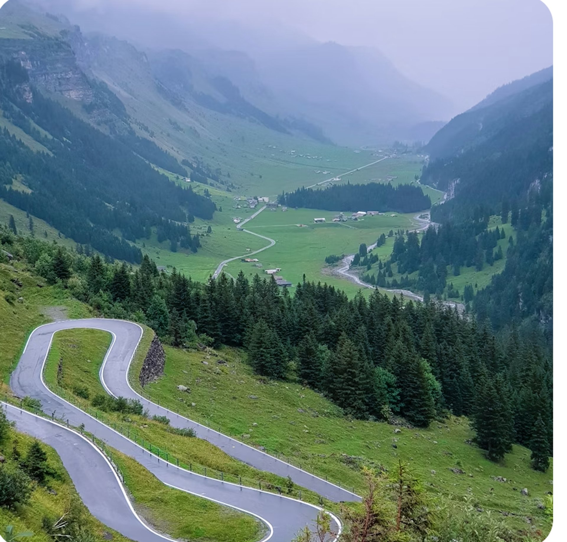 an aerial view of a winding road in the mountains