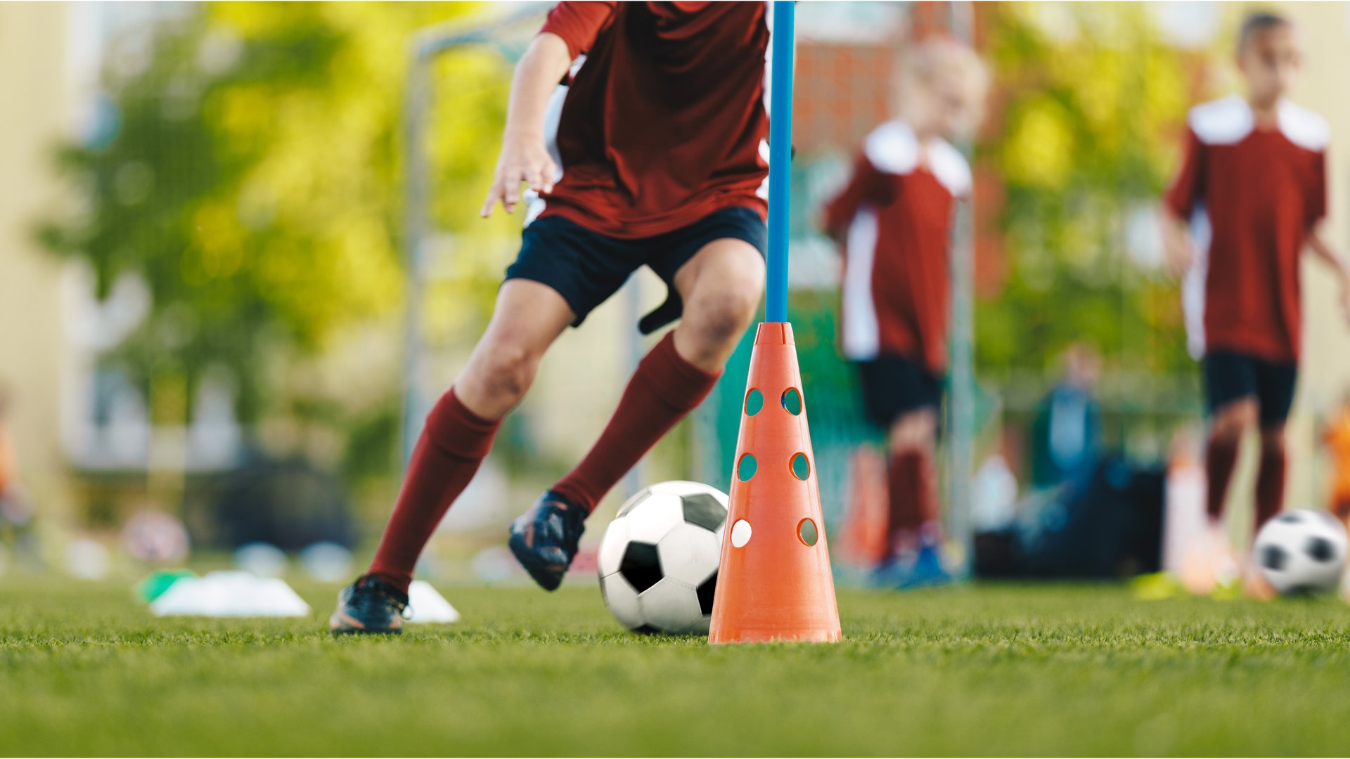Young man kicking soccer ball on field