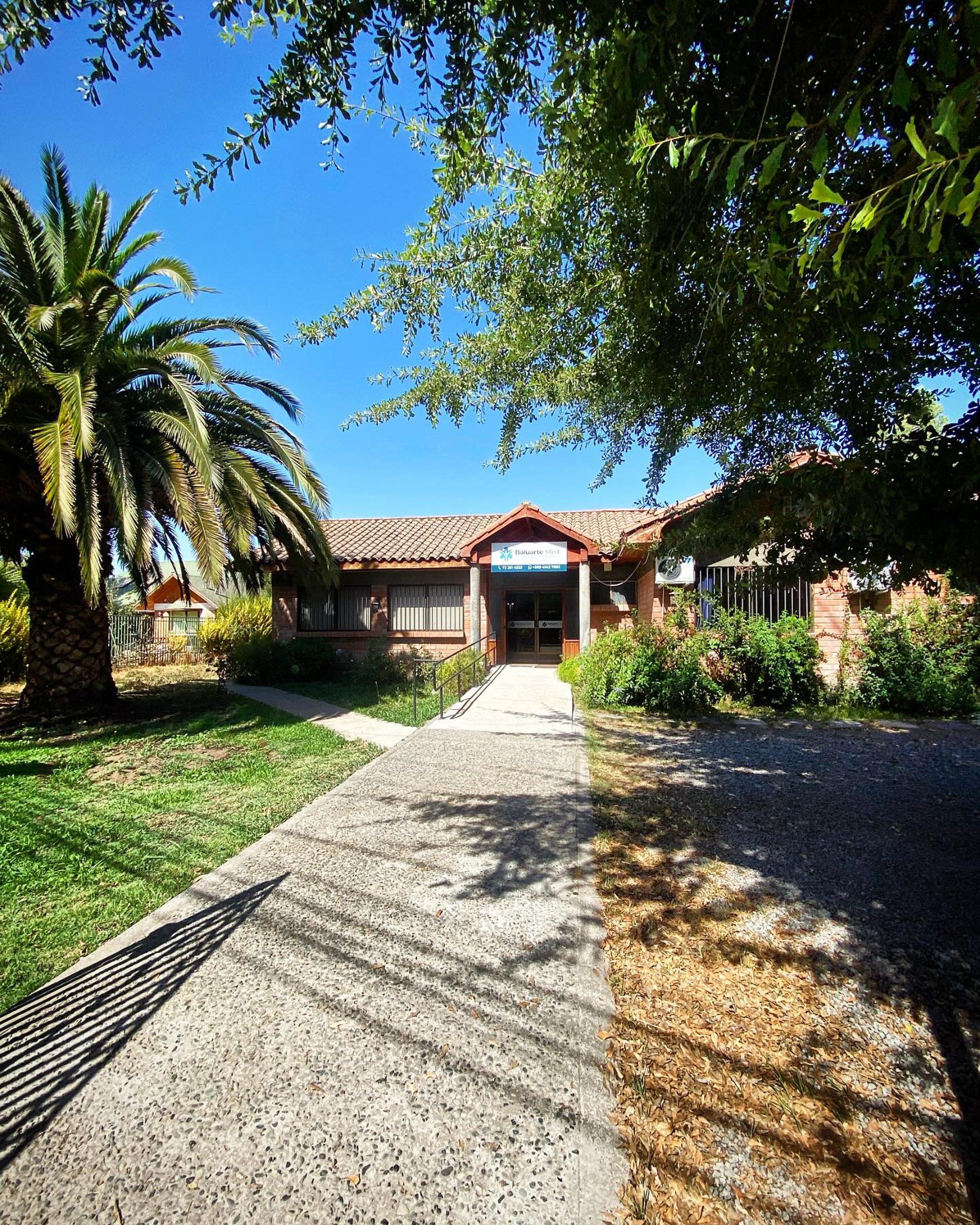 Doctor wearing a stethoscope sits at a desk.