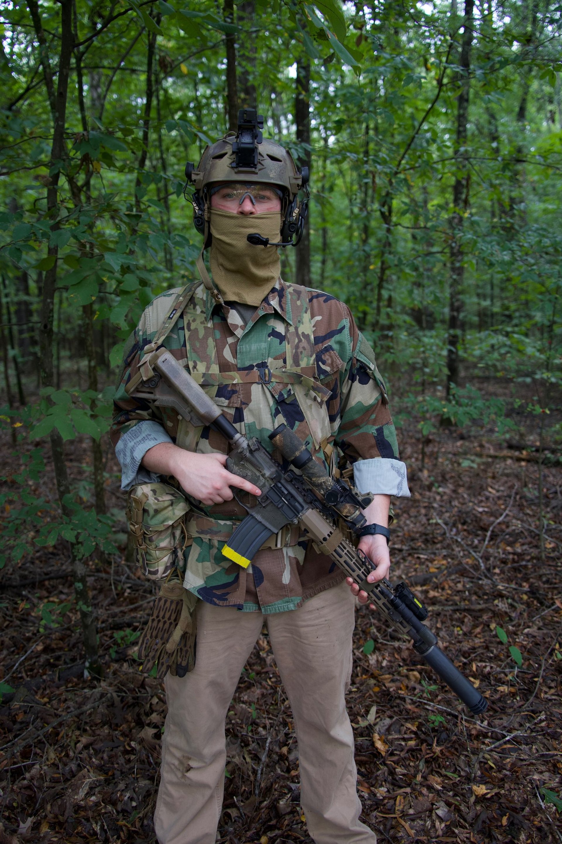 A man in camouflage walking through a forest
