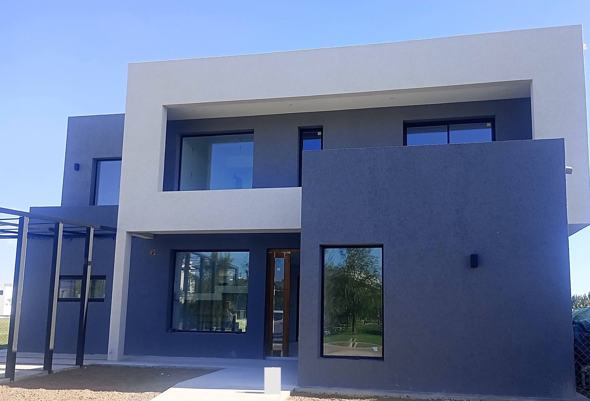 white concrete house near green tree during daytime