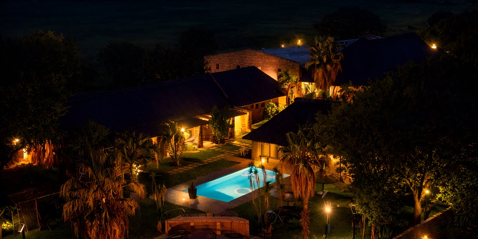 A couple of lions sitting on top of a dry grass field