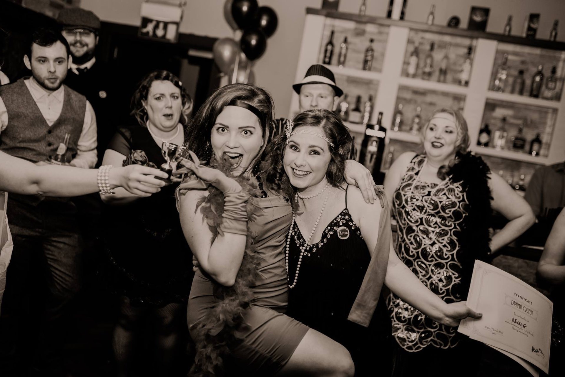 1920s themed murder mystery party. Lots of people are dressed up in a bar.