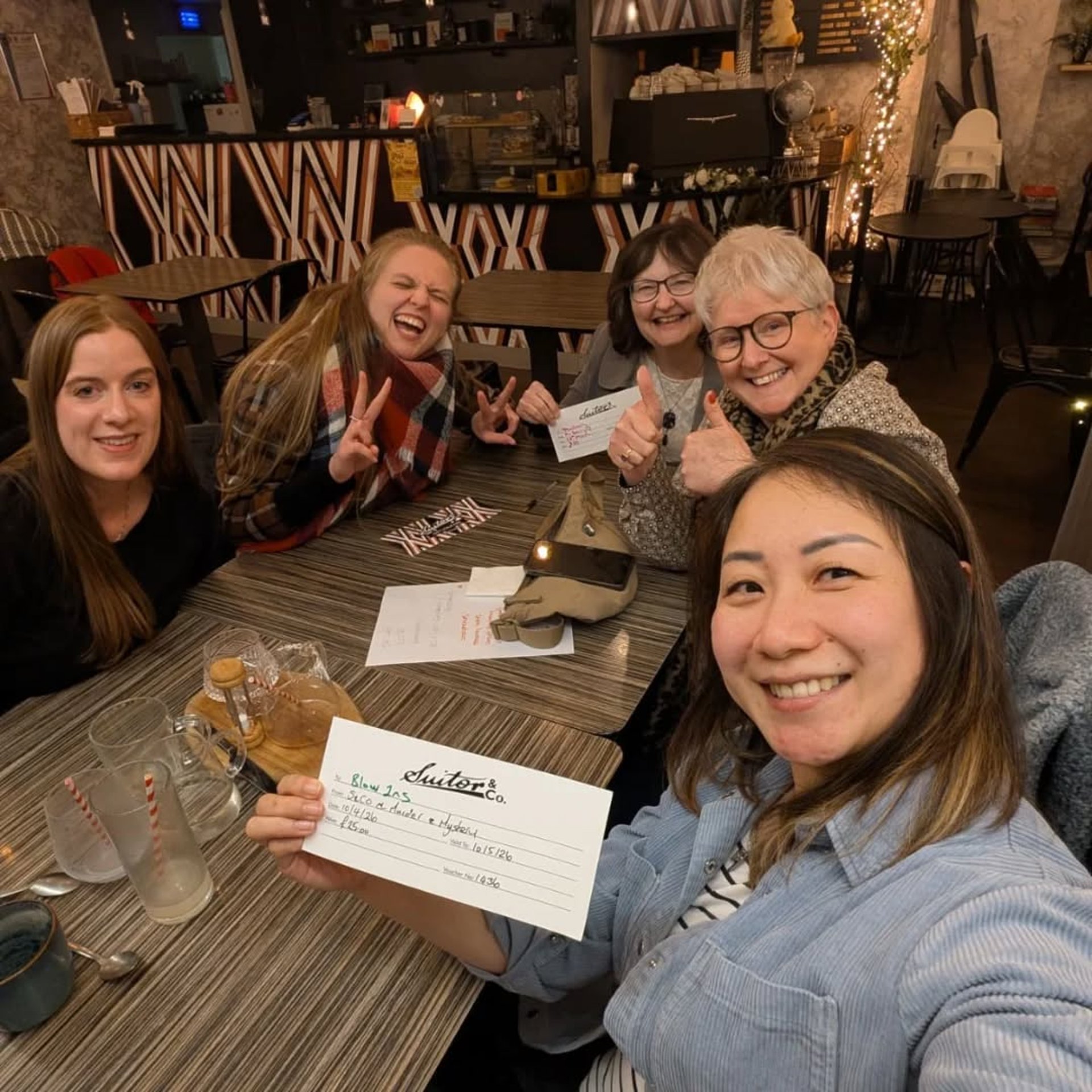 a group of women are smiling as they have won a quiz.