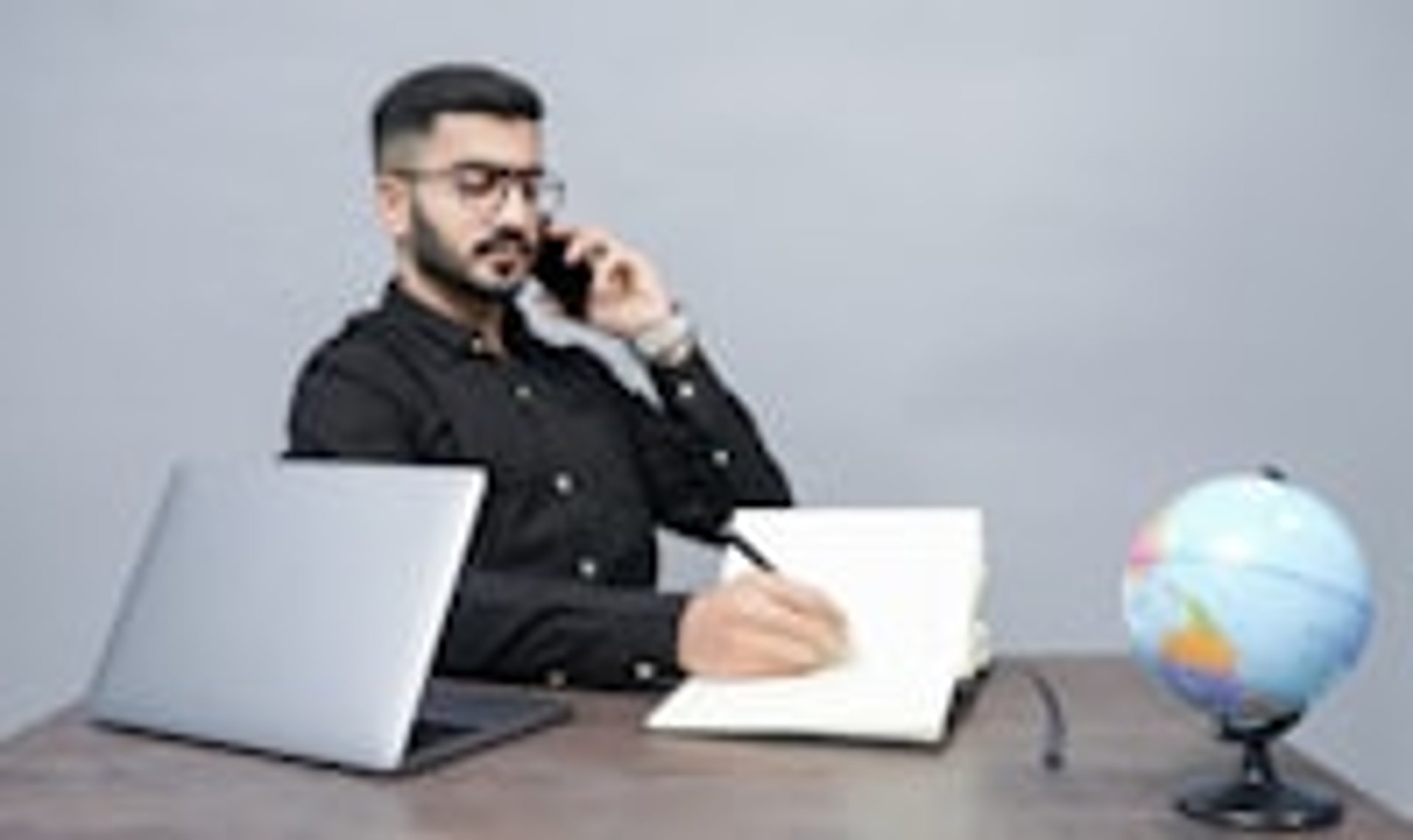 persona en oficina, escuhando a traves de un teléfono