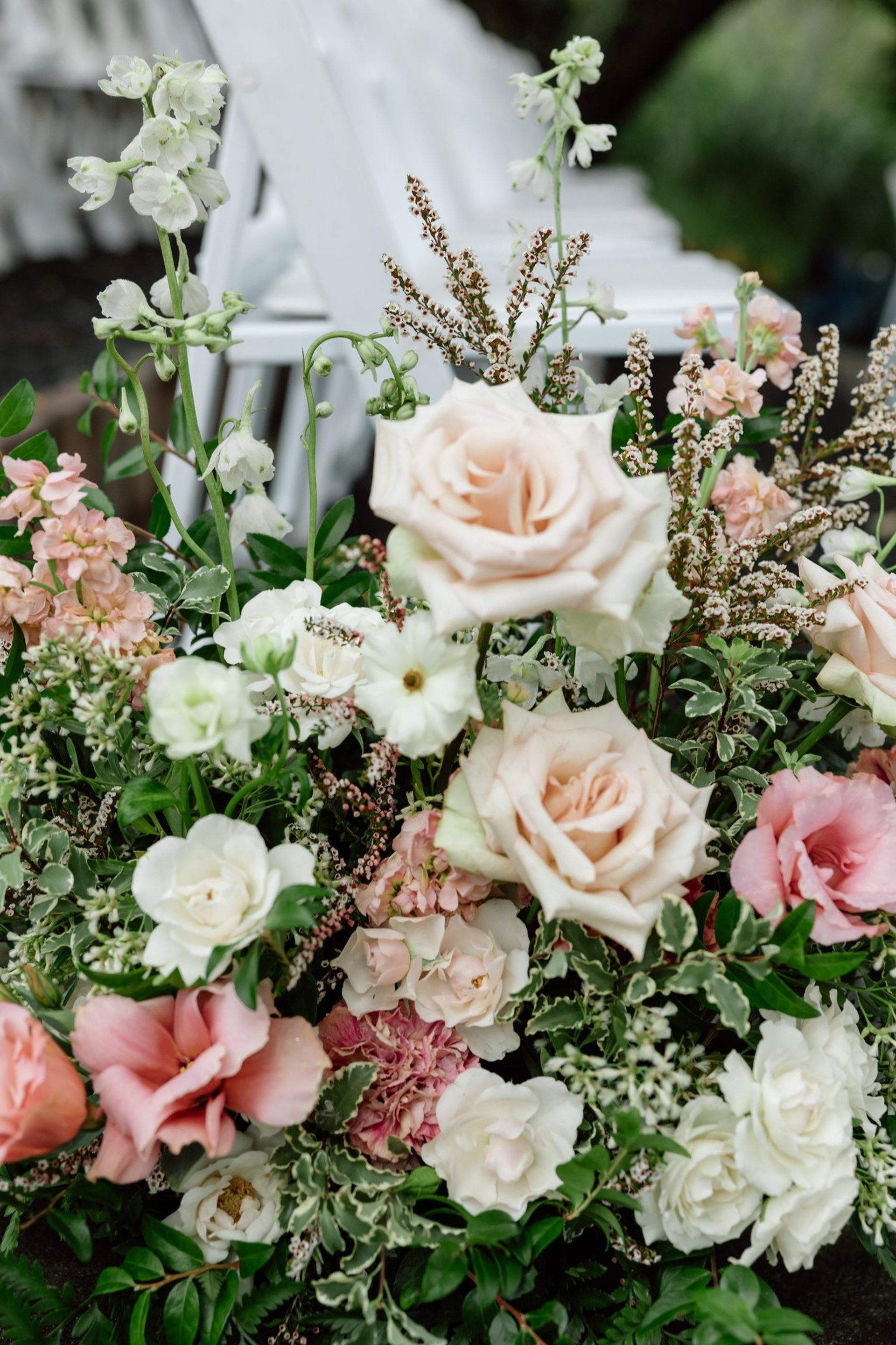 a white chair sitting next to a green plant