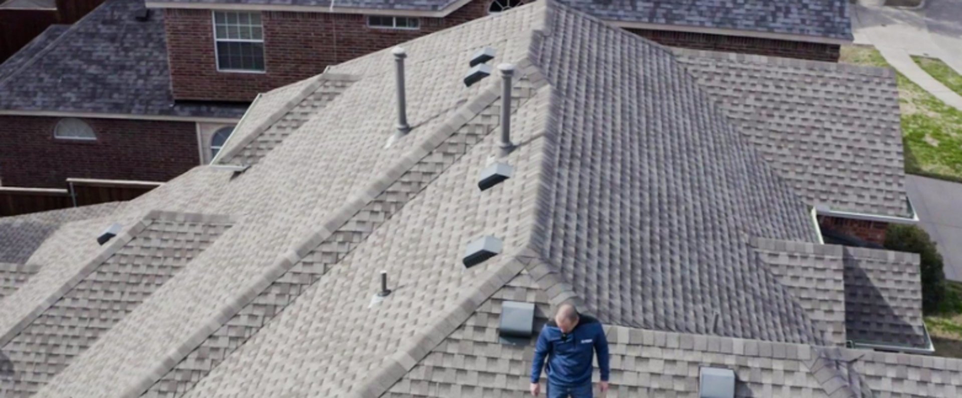 a man with a hammer on top of a roof
