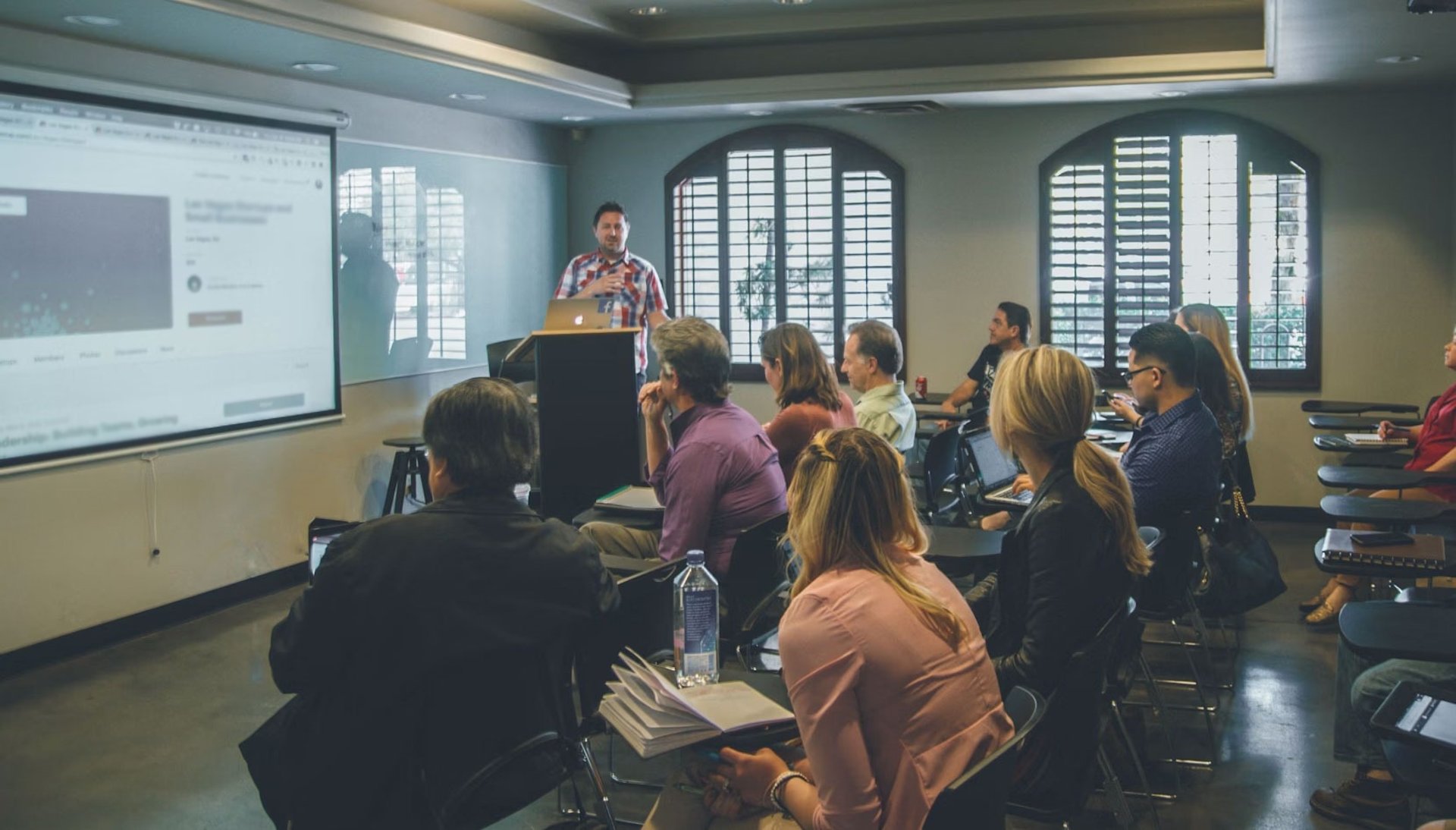 a group of people in a room with a projector screen
