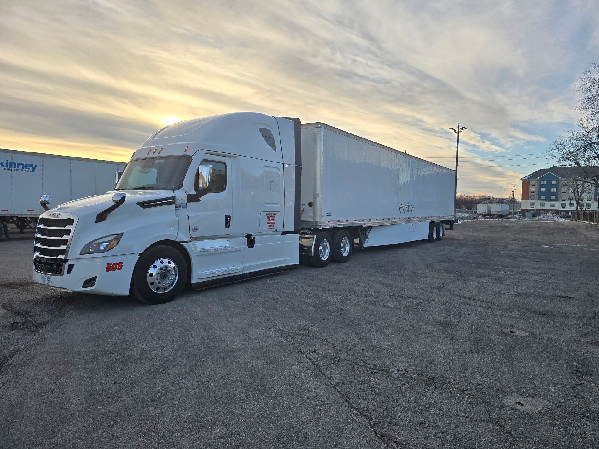a white semi truck driving down a rural road