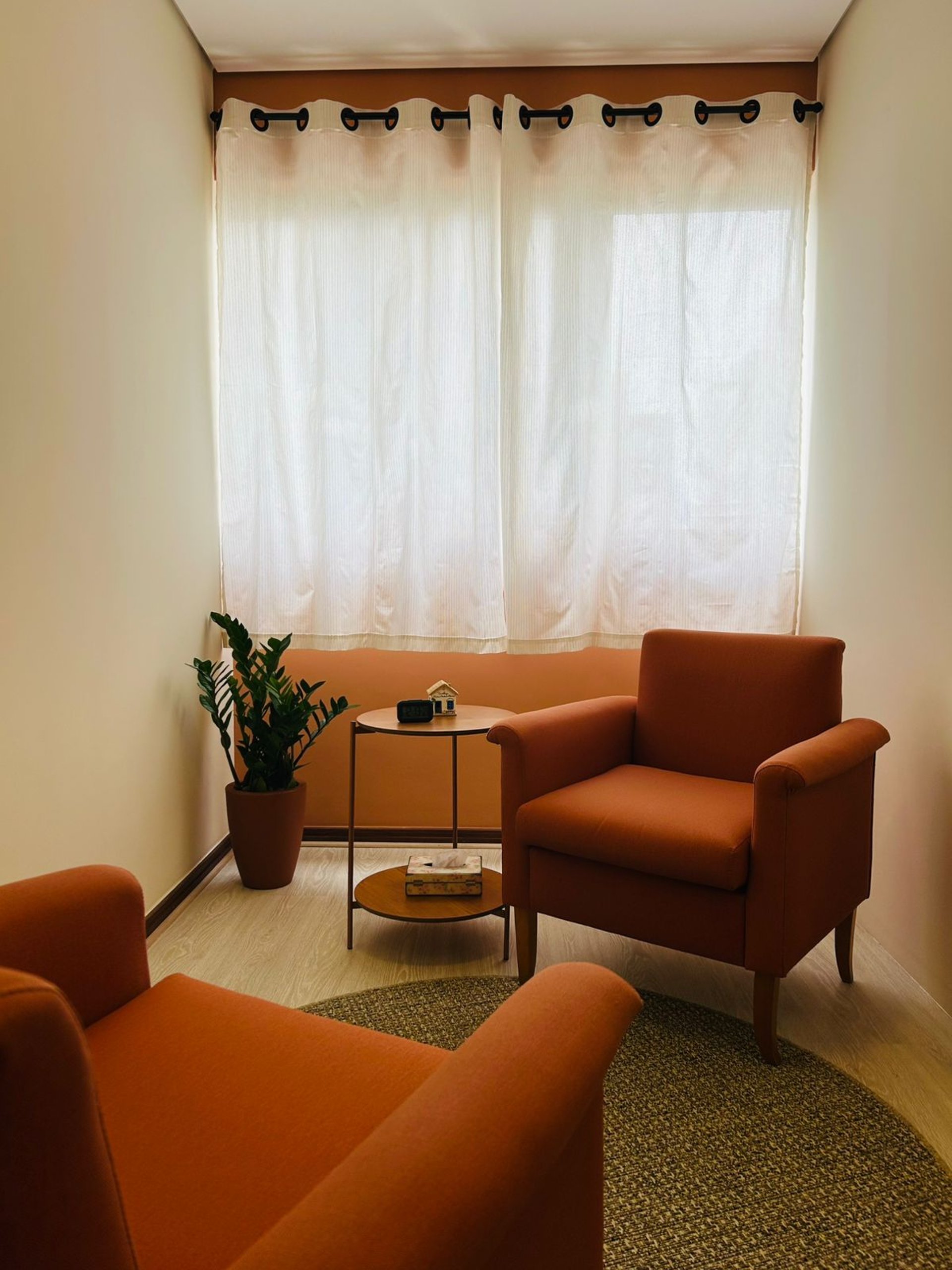person writing on brown wooden table near white ceramic mug