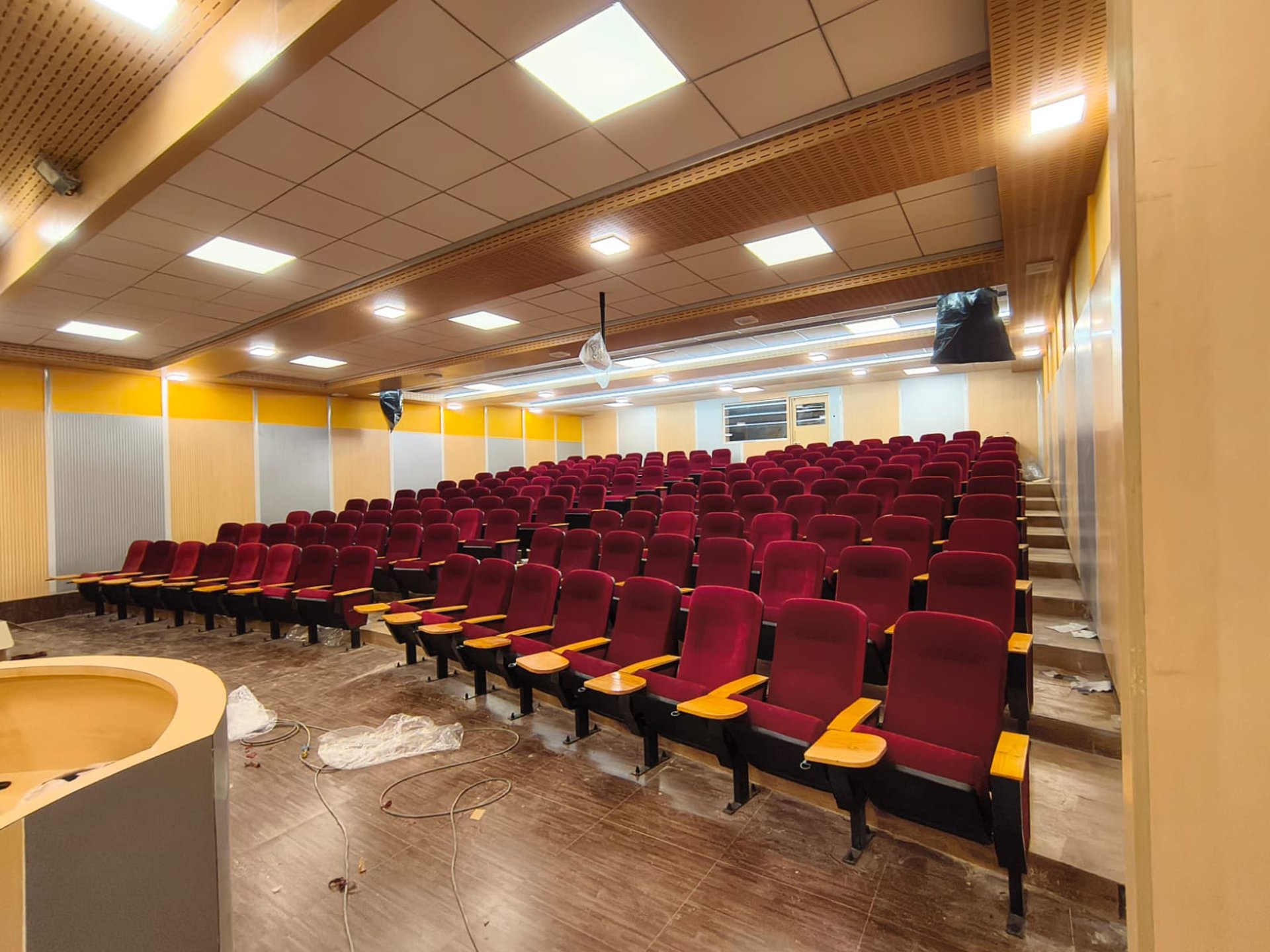 Rows of empty red theater seats facing a dark screen