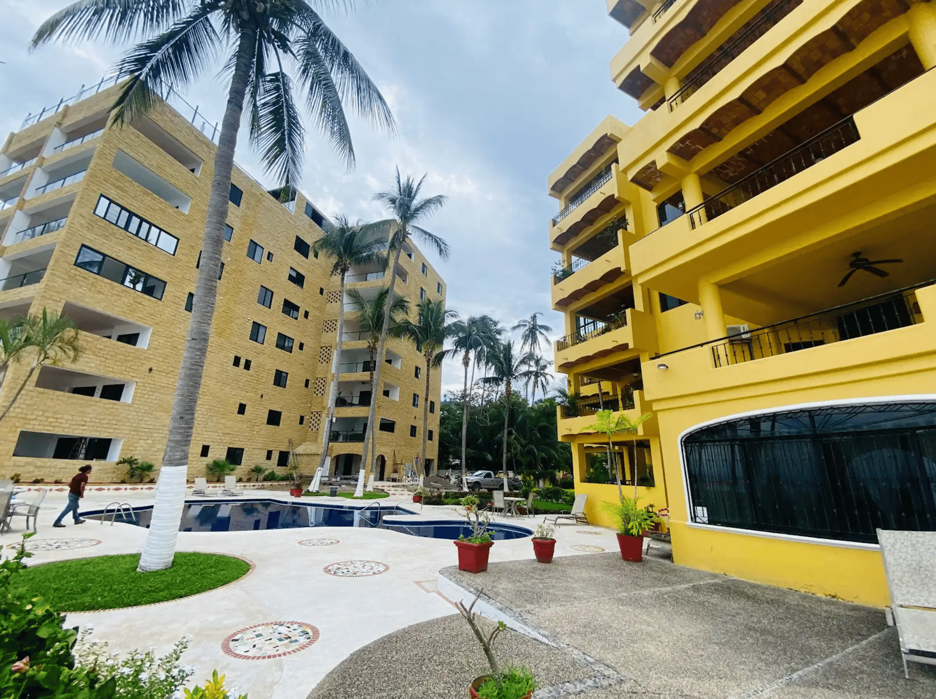 white and grey concrete building near swimming pool under clear sky during daytime