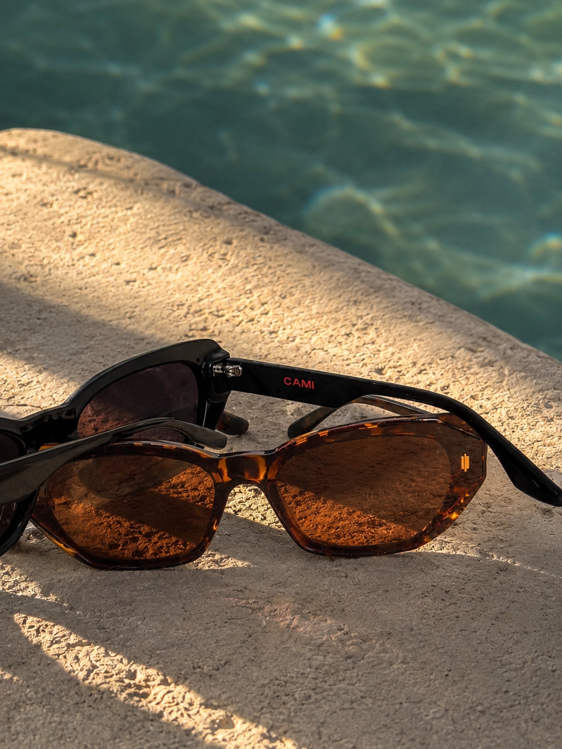 women's sunglasses and black bag with watch and iPhone 6