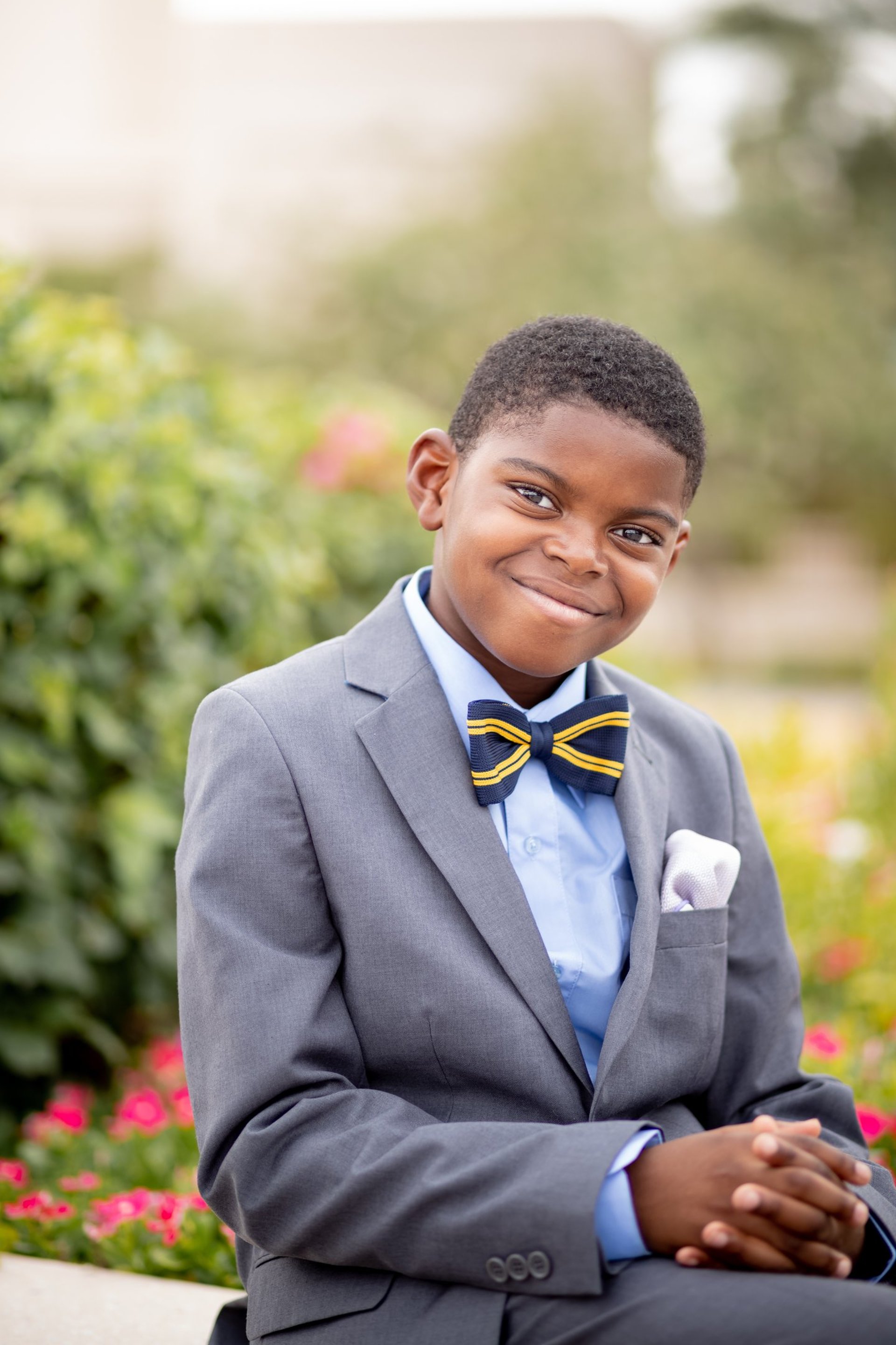 Smiling young boy in formal attire during an outdoor portrait session.