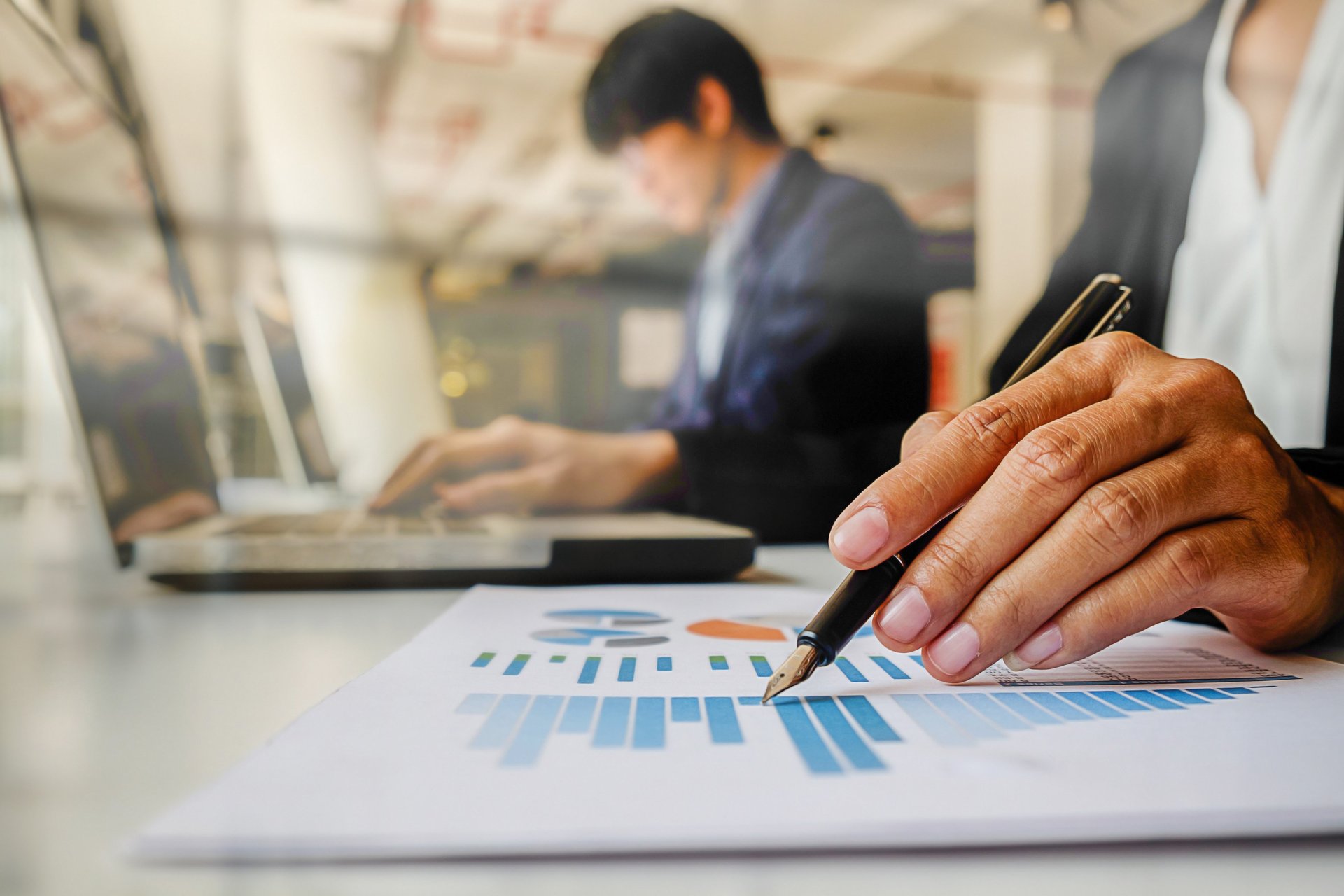 A businessman is holding a laptop and looking up.