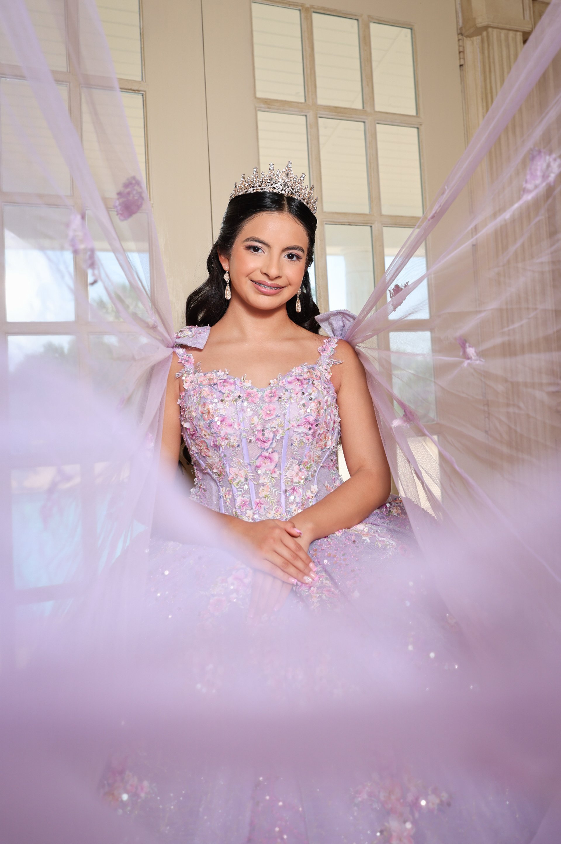 Young woman in a formal gown holding a bouquet.