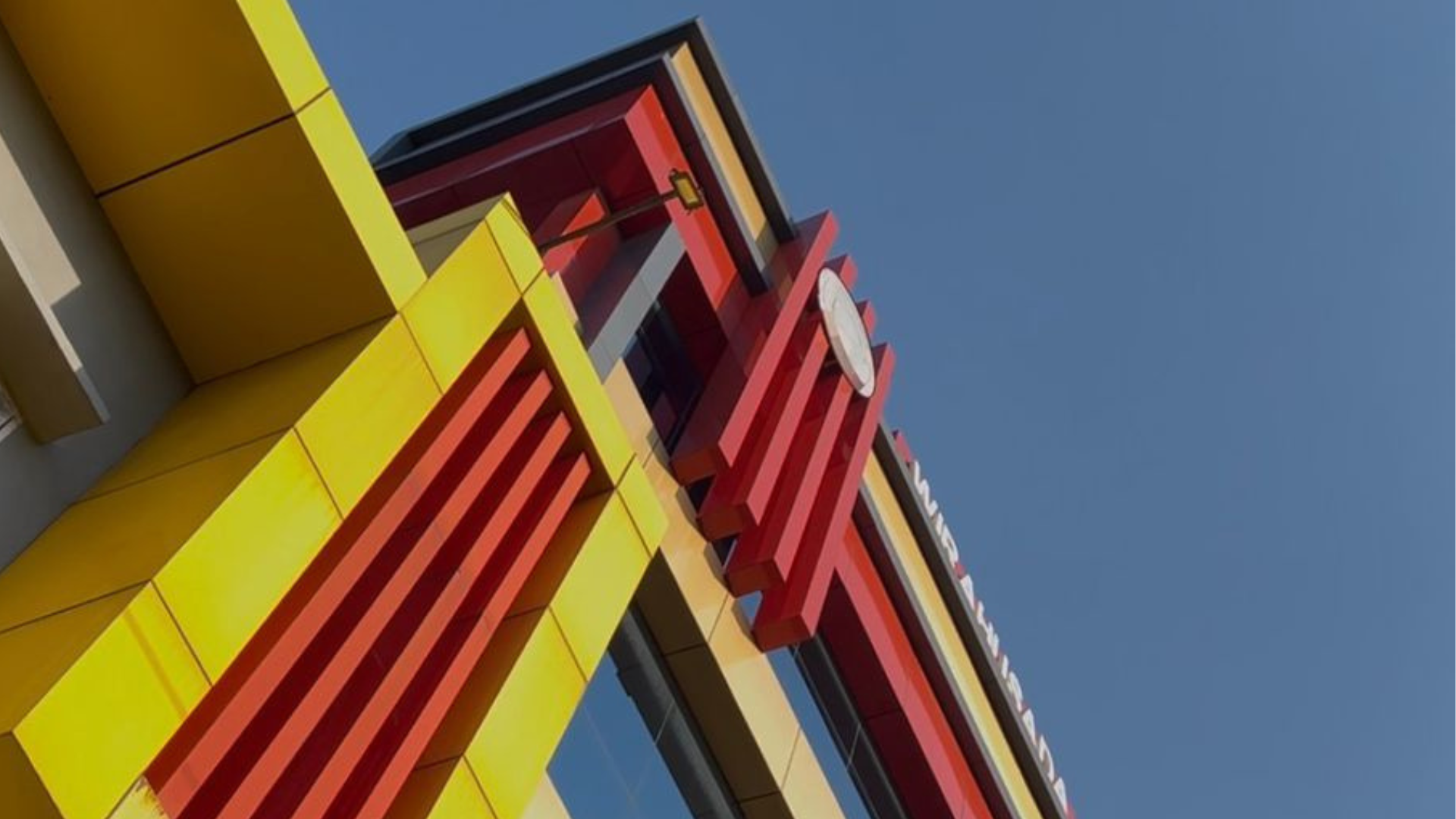 an abstract photo of a curved building with a blue sky in the background