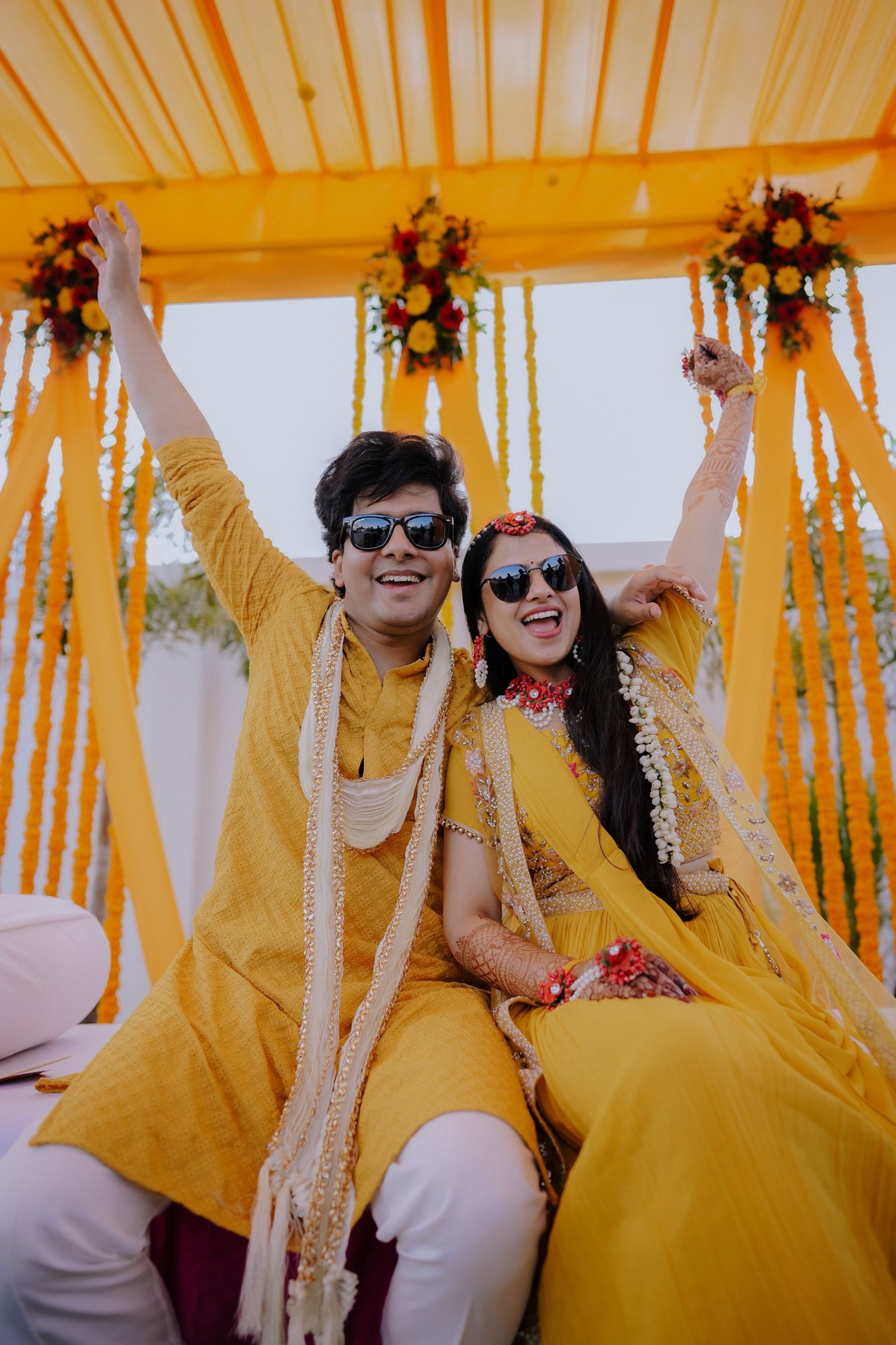 a group of people standing around a man covered in orange and yellow flowers