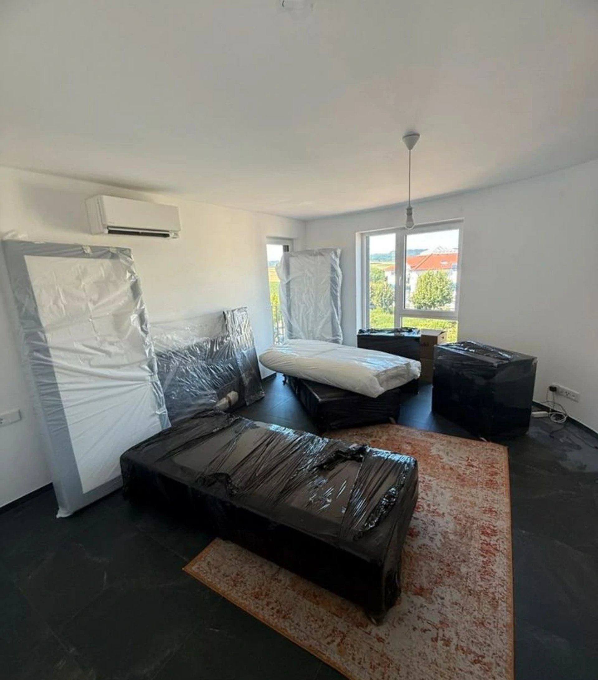 a woman moving boxes in a living room