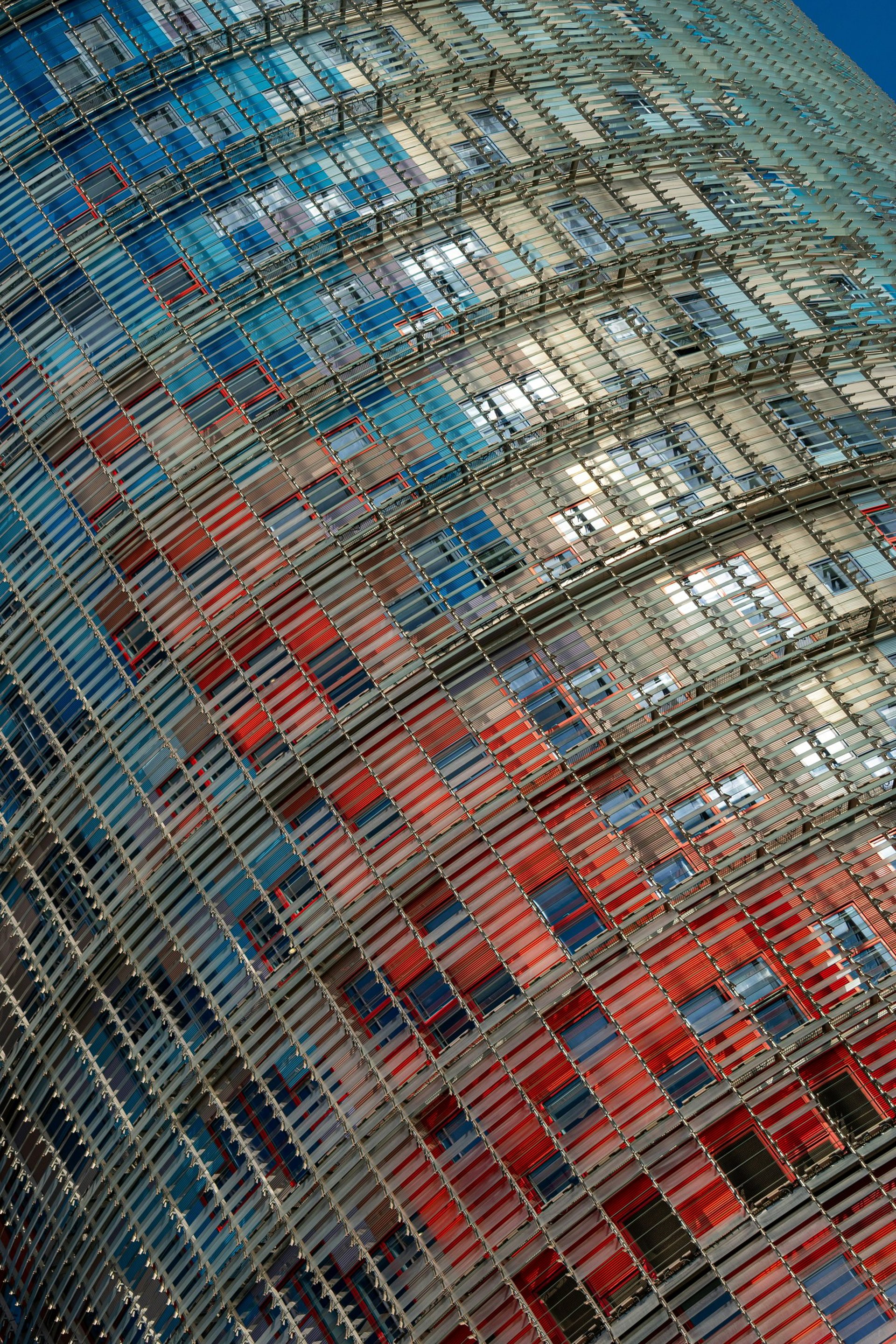 an abstract photo of a curved building with a blue sky in the background