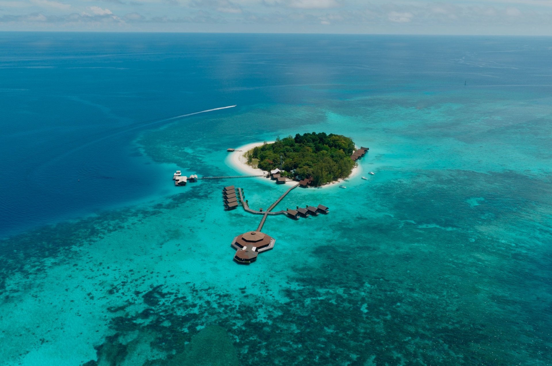 Wide drone view of Lankayan Island from the front showing the resort and shoreline