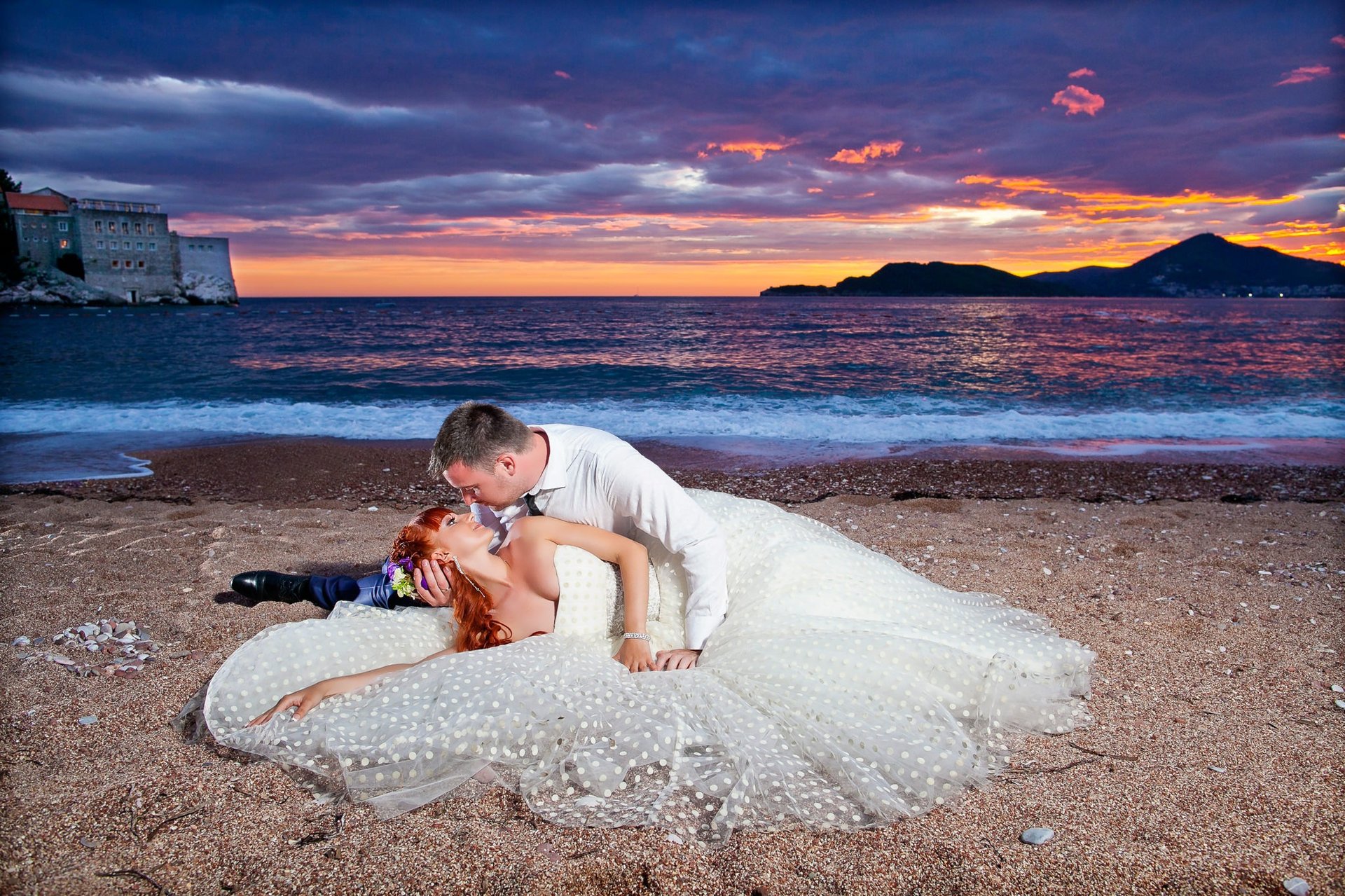Sunset wedding photoshoot Budva beach Adriatic Sea - Bride in white dress with groom on sandy beach Montenegro